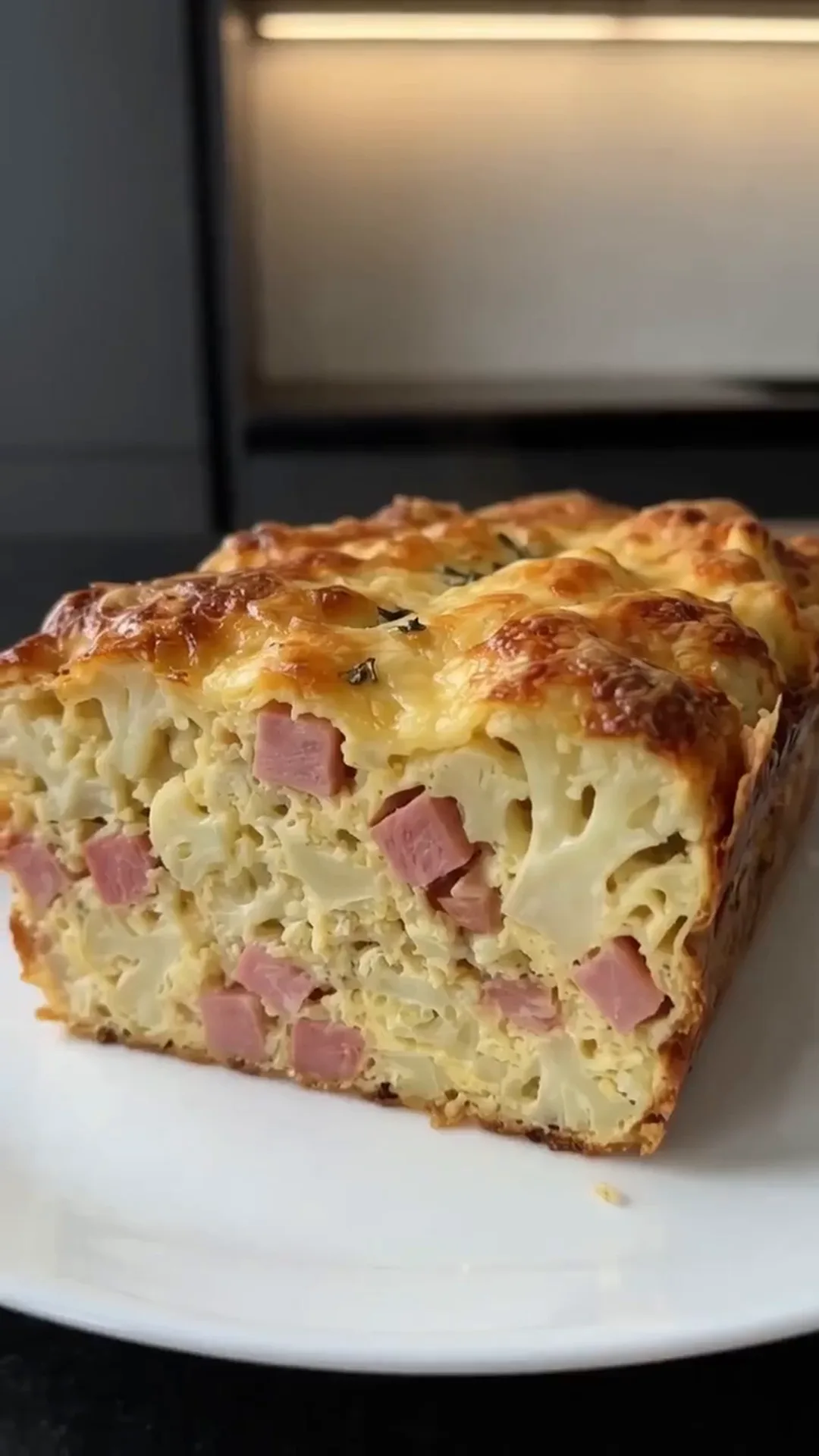 Cheesy Cauliflower and Smoked Turkey Casserole Bake – A slice of a casserole is being presented on a plate