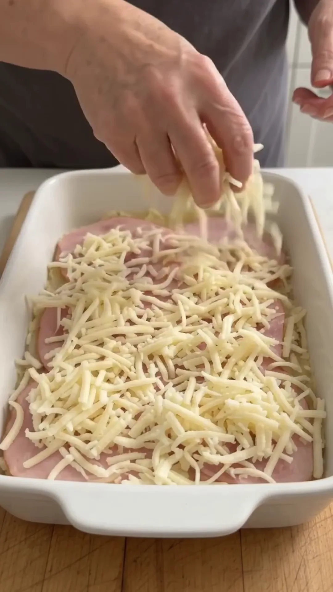 Cheesy Cauliflower Beef Stacks with Mozzarella and Parmesan – Adding cheese to a dish in a baking tray