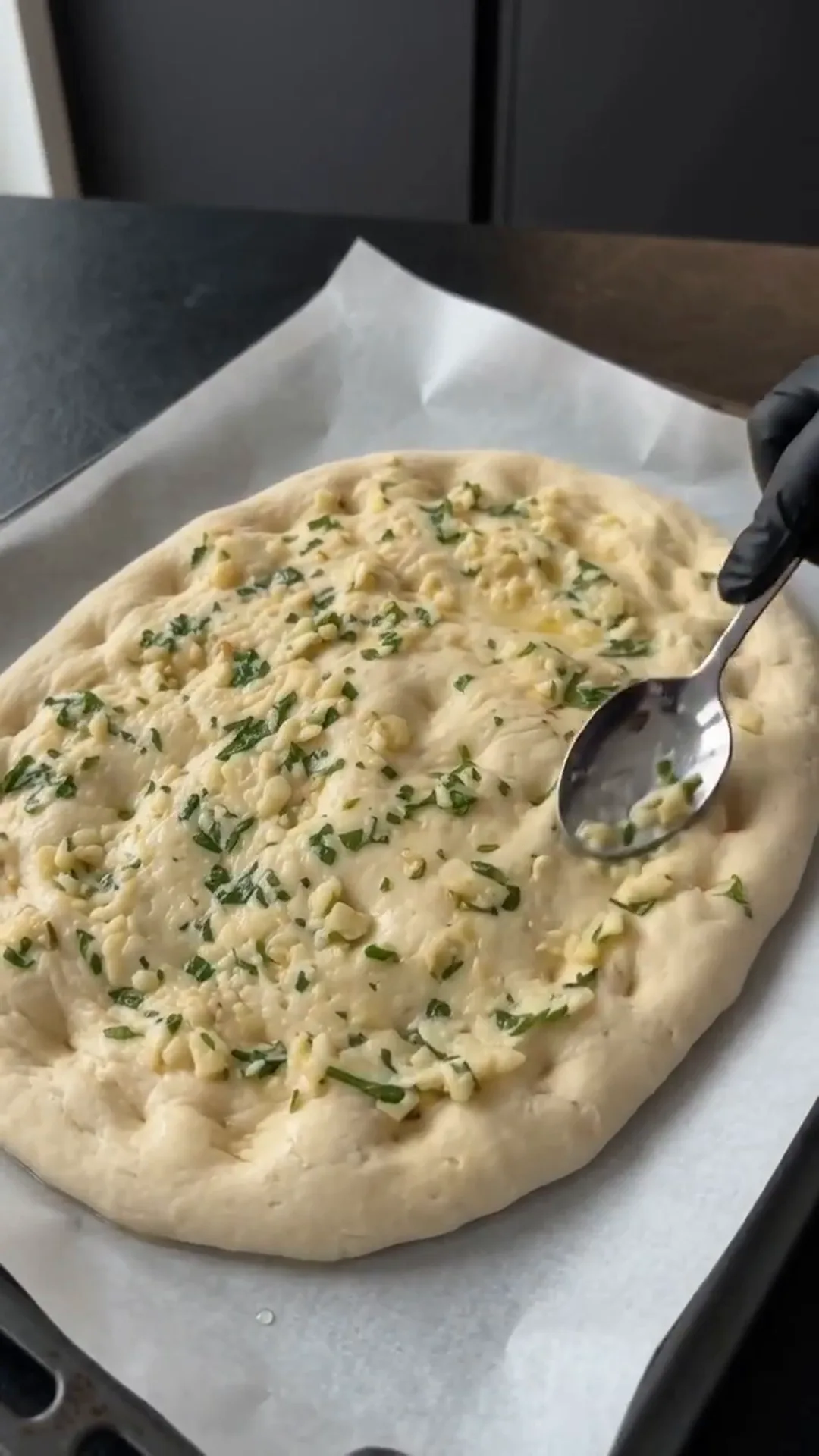 Cheesy Garlic Herb Flatbread Strips Recipe – spooning garlic and herbs onto dough