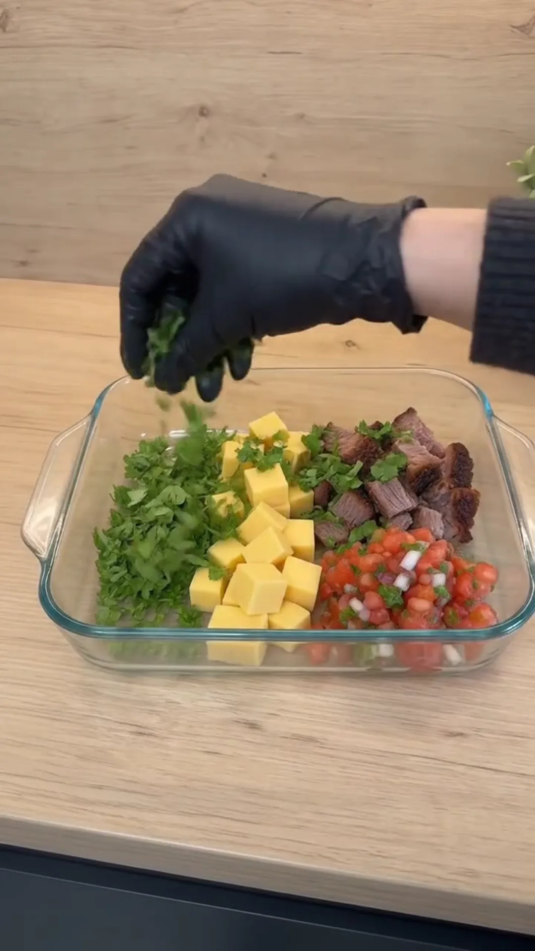 Creamy Smoked Brisket Queso Dip Recipe – A person is adding herbs to a salad