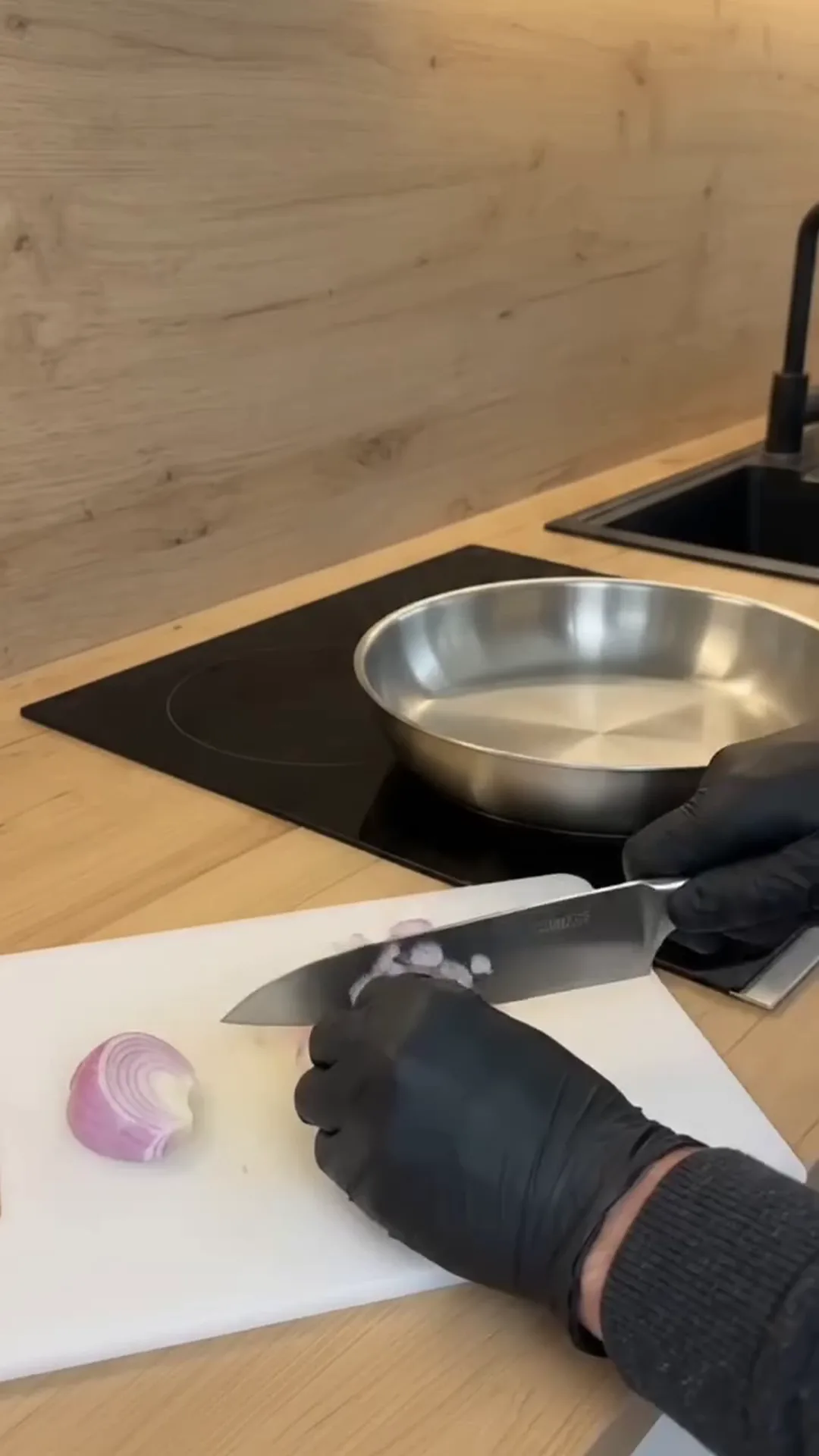 Creamy Sun-Dried Tomato Braised Cabbage Roasted Wedges – A person is chopping an onion on a cutting board