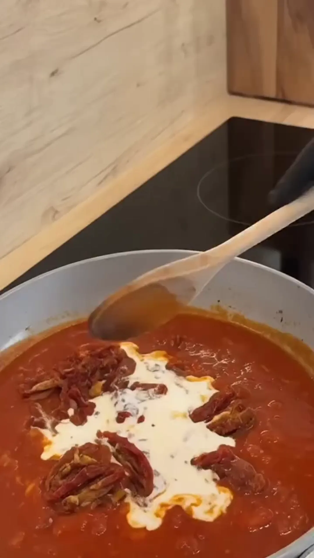 Creamy Sun-Dried Tomato Braised Cabbage Roasted Wedges – A person is stirring a large pot of tomato sauce