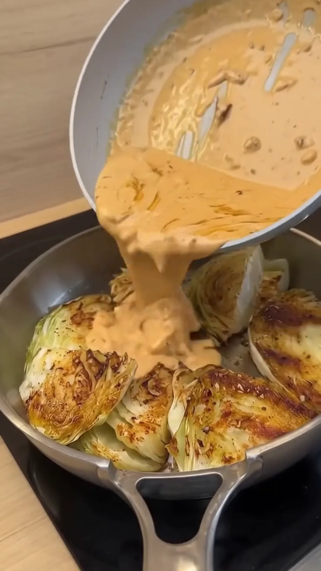 Creamy Sun-Dried Tomato Braised Cabbage Roasted Wedges – Pouring sauce over cabbage in a pan