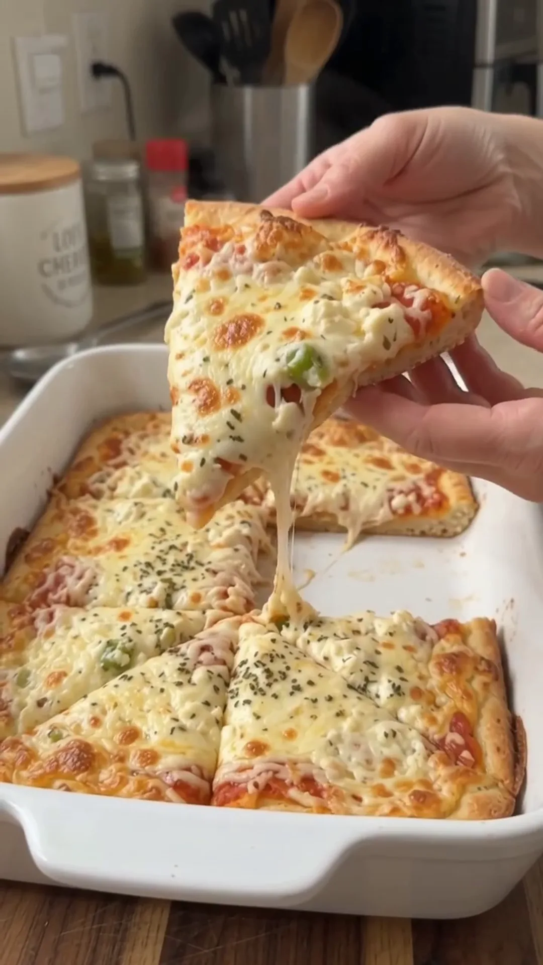 Crispy 3-Ingredient Cottage Cheese Pizza Crust – pulling a slice of pizza out of a baking dish