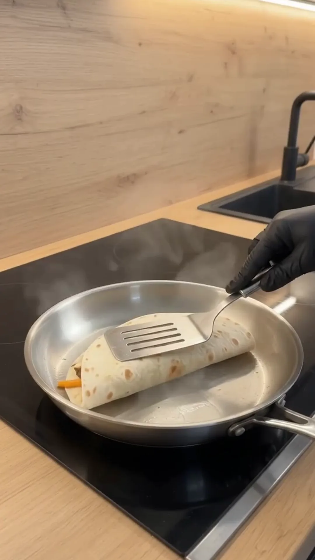 Crispy Cheeseburger Wrap with Golden French Fries – A person is cooking a burrito in a pan