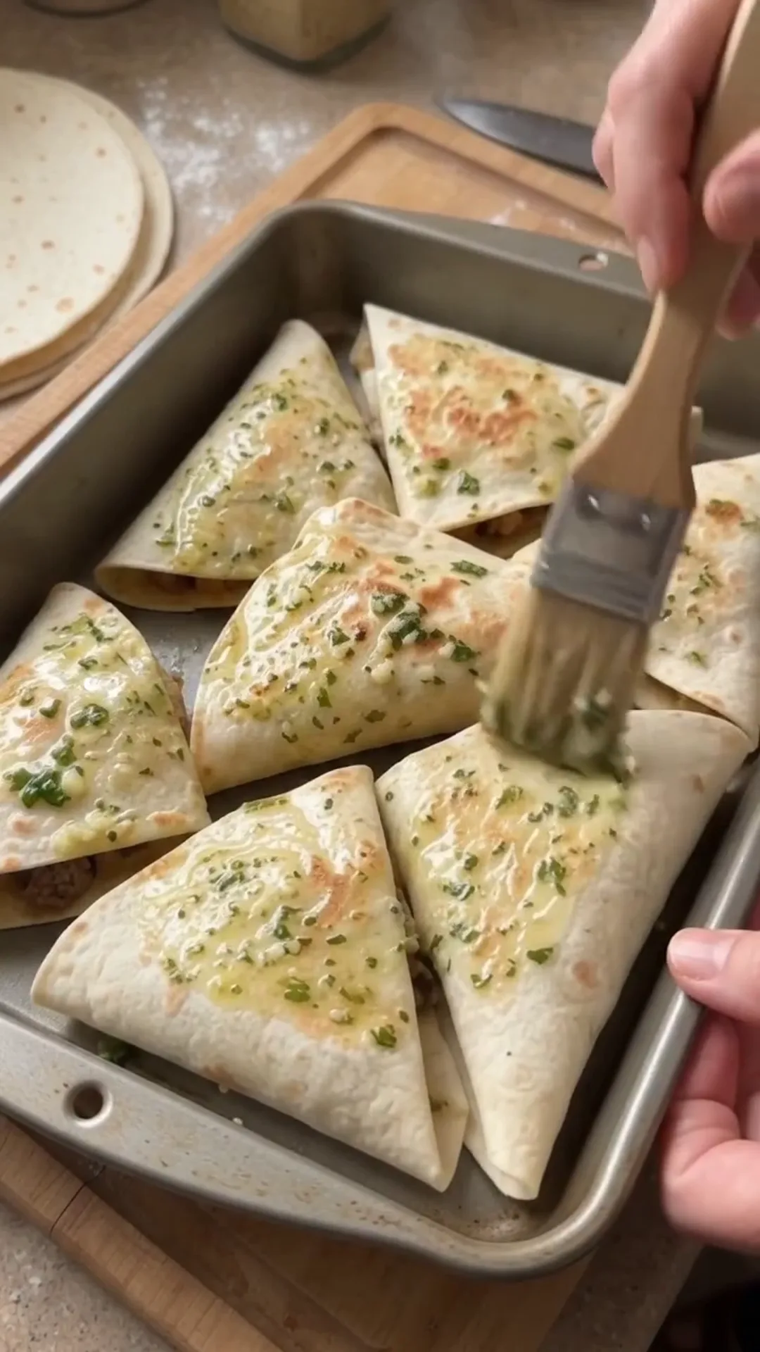 Crispy Cheesy Beef Tortilla Pockets Recipe – brushing melted cheese on quesadillas