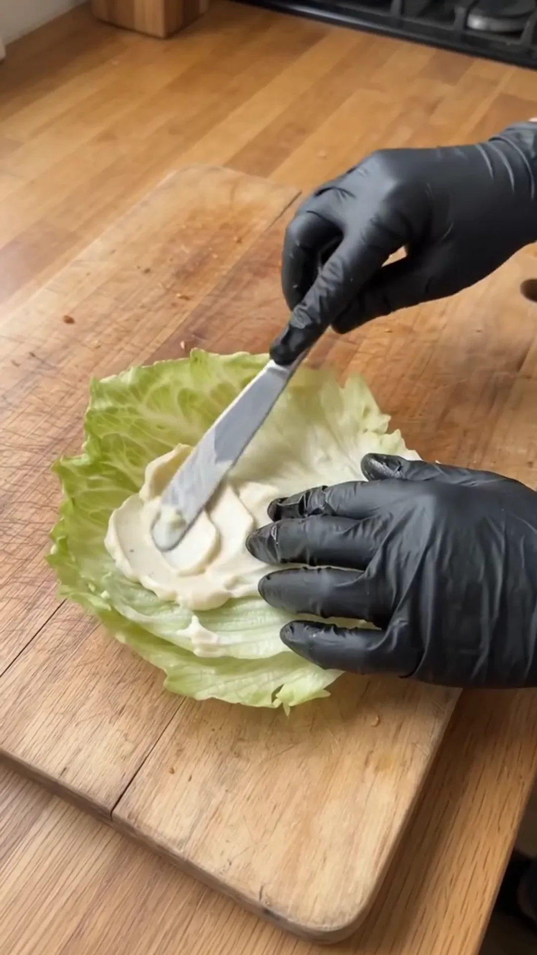 Crispy Chicken Lettuce Wraps with Avocado and Sauce – A person is spreading mayonnaise on a lettuce leaf