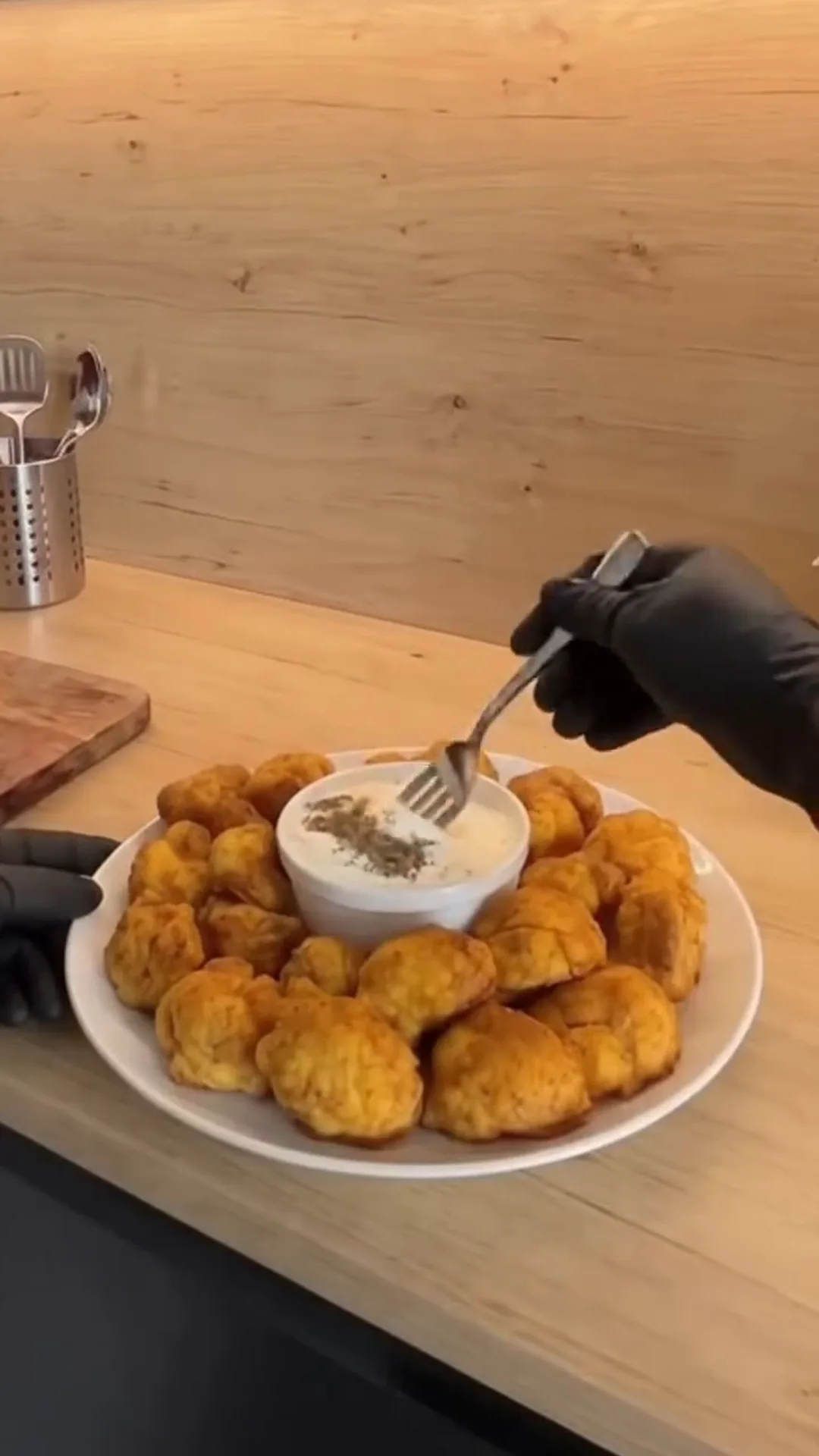 Crispy Oven-Baked Cauliflower Bites with Garlic Yogurt – Someone is preparing food, possibly fried chicken nuggets