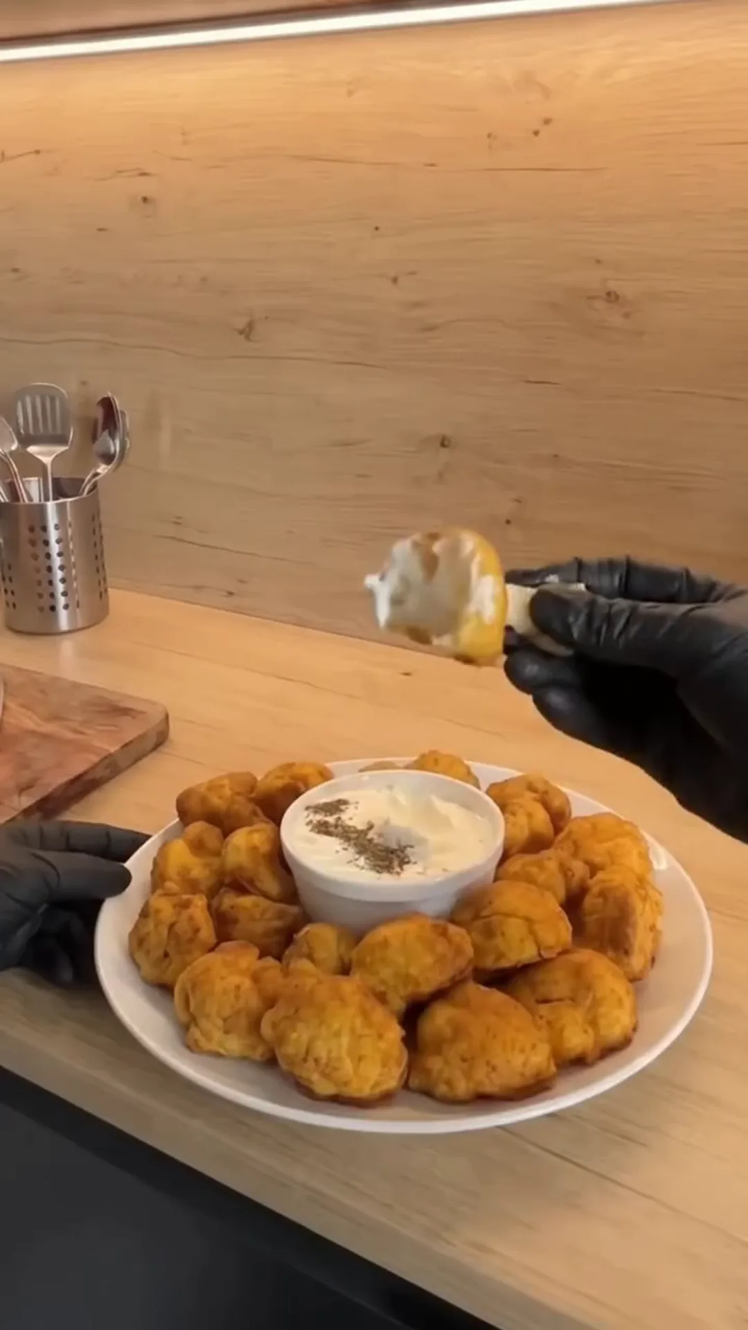 Crispy Oven-Baked Cauliflower Bites with Garlic Yogurt – person dipping food into a sauce