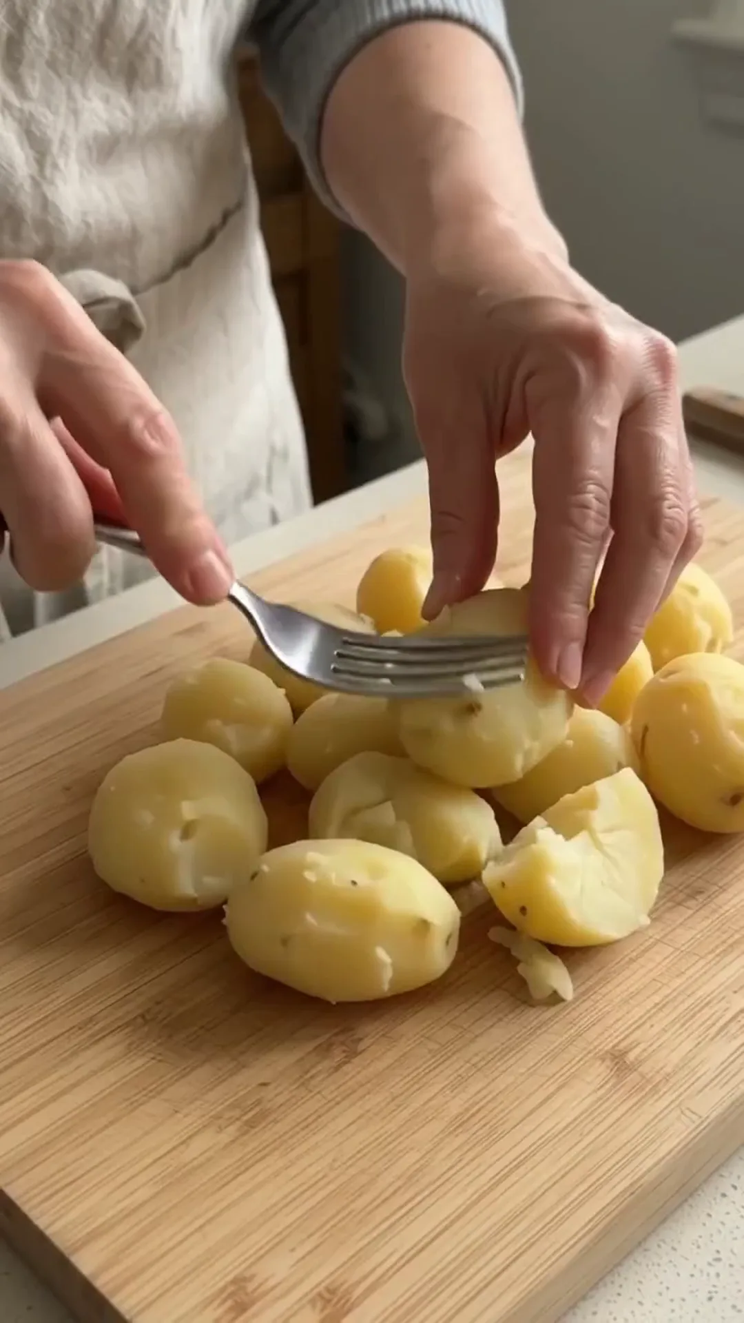 Crispy Potato Crust and Egg Breakfast Skillet Pizza – peeling potatoes with a fork on a wooden cutting board