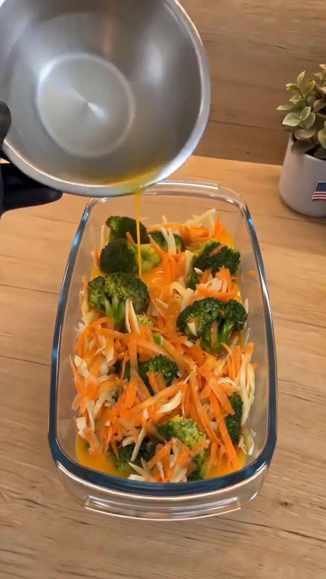 Easy Baked Broccoli Vegetable Omelet with Melted Cheese – Pouring orange liquid into a glass baking dish with vegetables