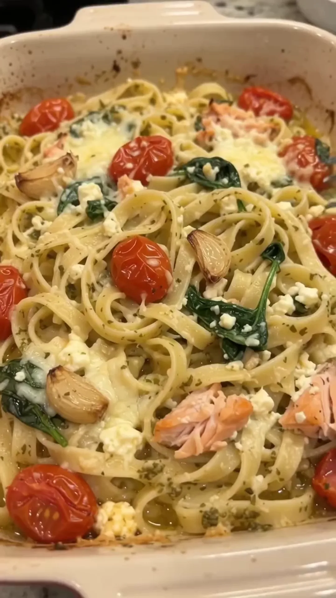 Easy Baked Salmon and Feta Pasta with Creamy Sauce – pasta with salmon, spinach, tomatoes, and feta cheese is being served