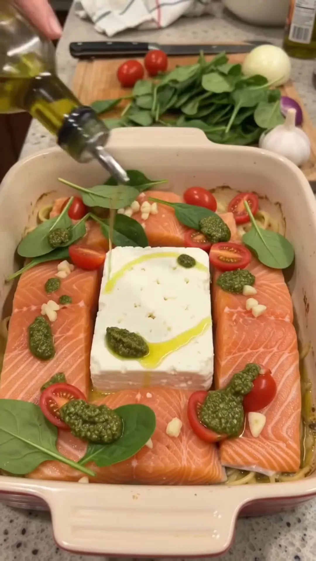 Easy Baked Salmon and Feta Pasta with Creamy Sauce – Pouring oil over salmon in a baking dish