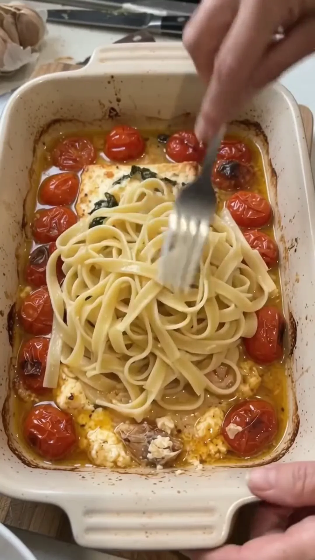 Easy Baked Salmon and Feta Pasta with Creamy Sauce – person is placing pasta in a baking dish
