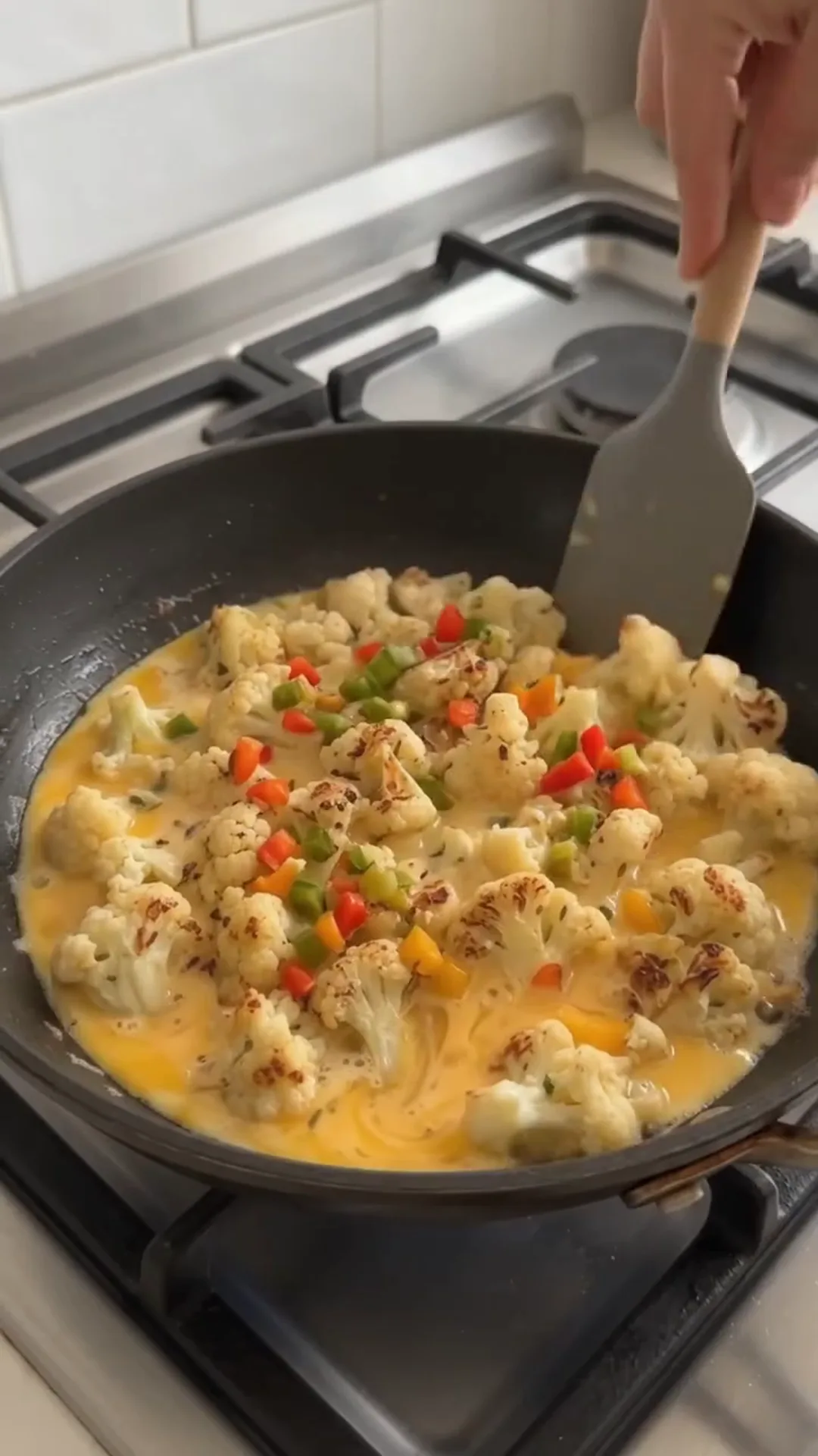 Easy Pan Fried Cauliflower and Eggs with Fresh Dill – person stirring a pan of scrambled eggs and vegetables