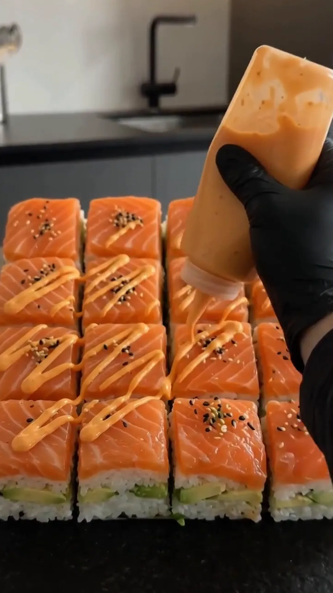 Easy Salmon Avocado Sushi Squares with Spicy Mayo – someone is drizzling sauce on sushi