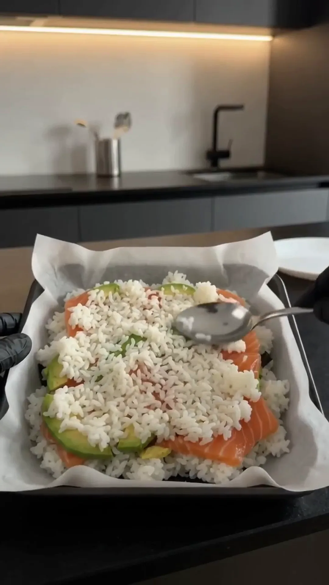 Easy Salmon Avocado Sushi Squares with Spicy Mayo – a person is preparing a dish with rice and salmon