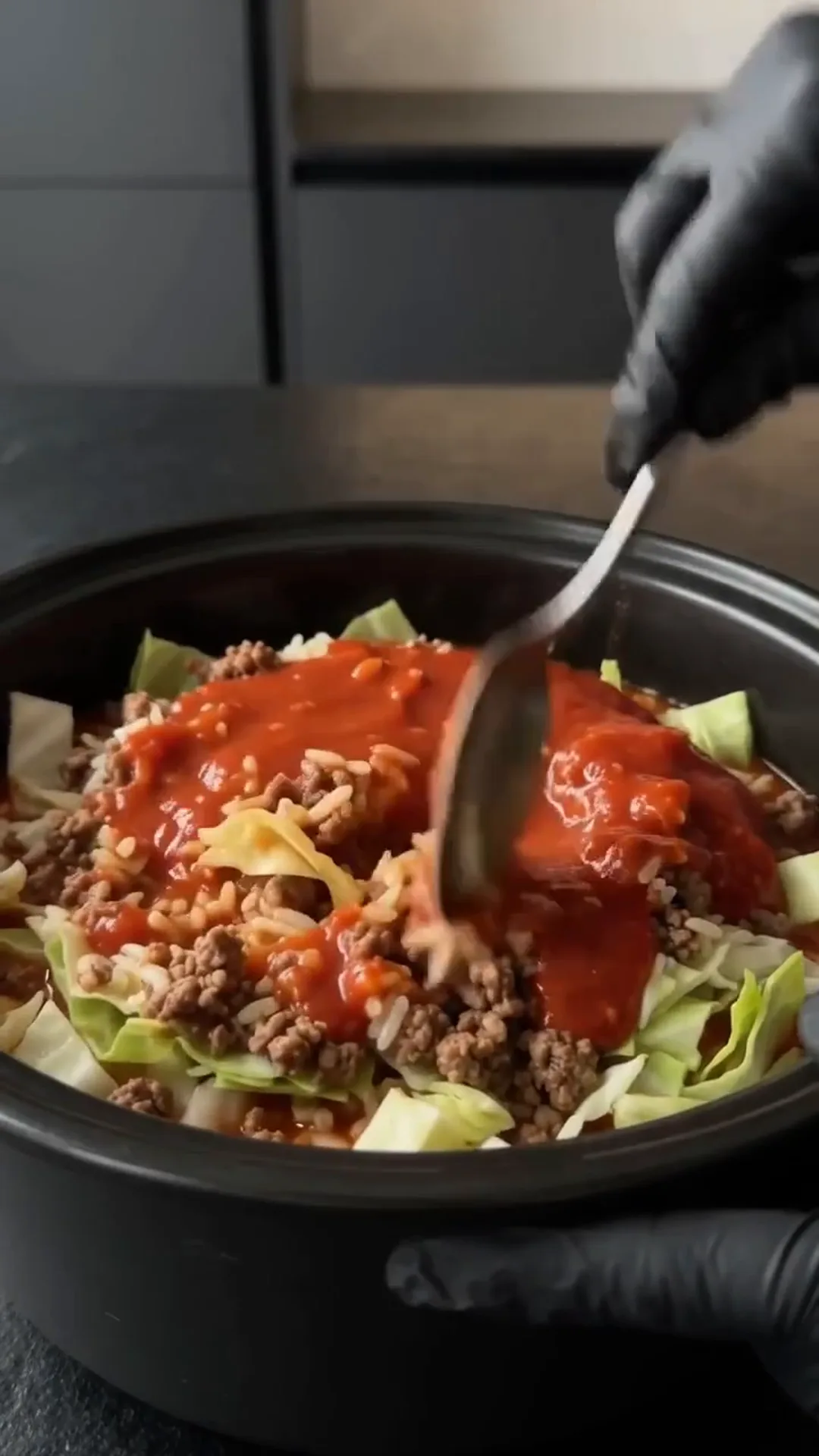 Easy slow cooker Cabbage Roll Casserole with Ground Beef – person is mixing a salad with a spoon