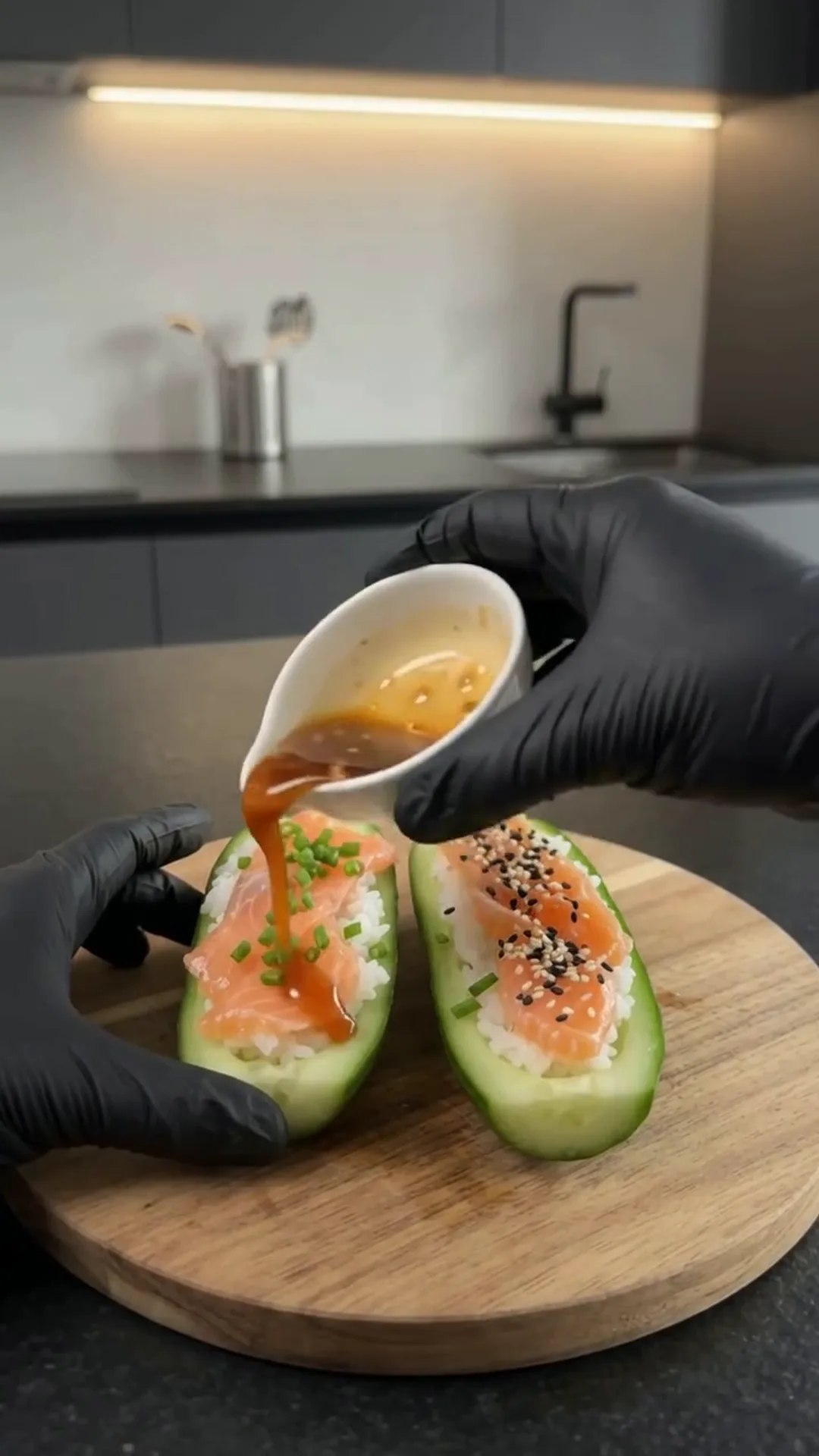 Easy Smoked Salmon Cucumber Sushi Boats – Pouring sauce onto sushi-like food on a wooden board