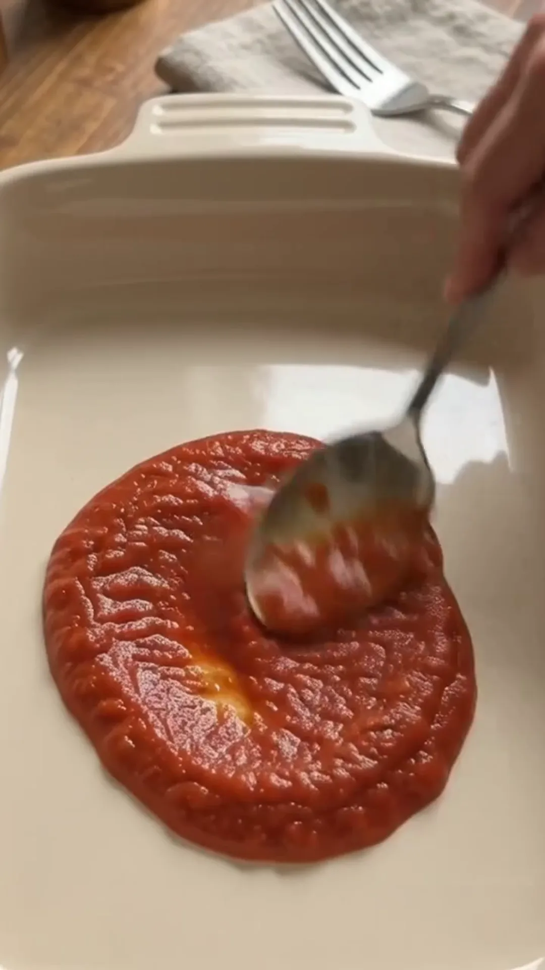 Easy Unbreaded Baked Eggplant Parmesan Recipe – spooning tomato sauce into a baking dish