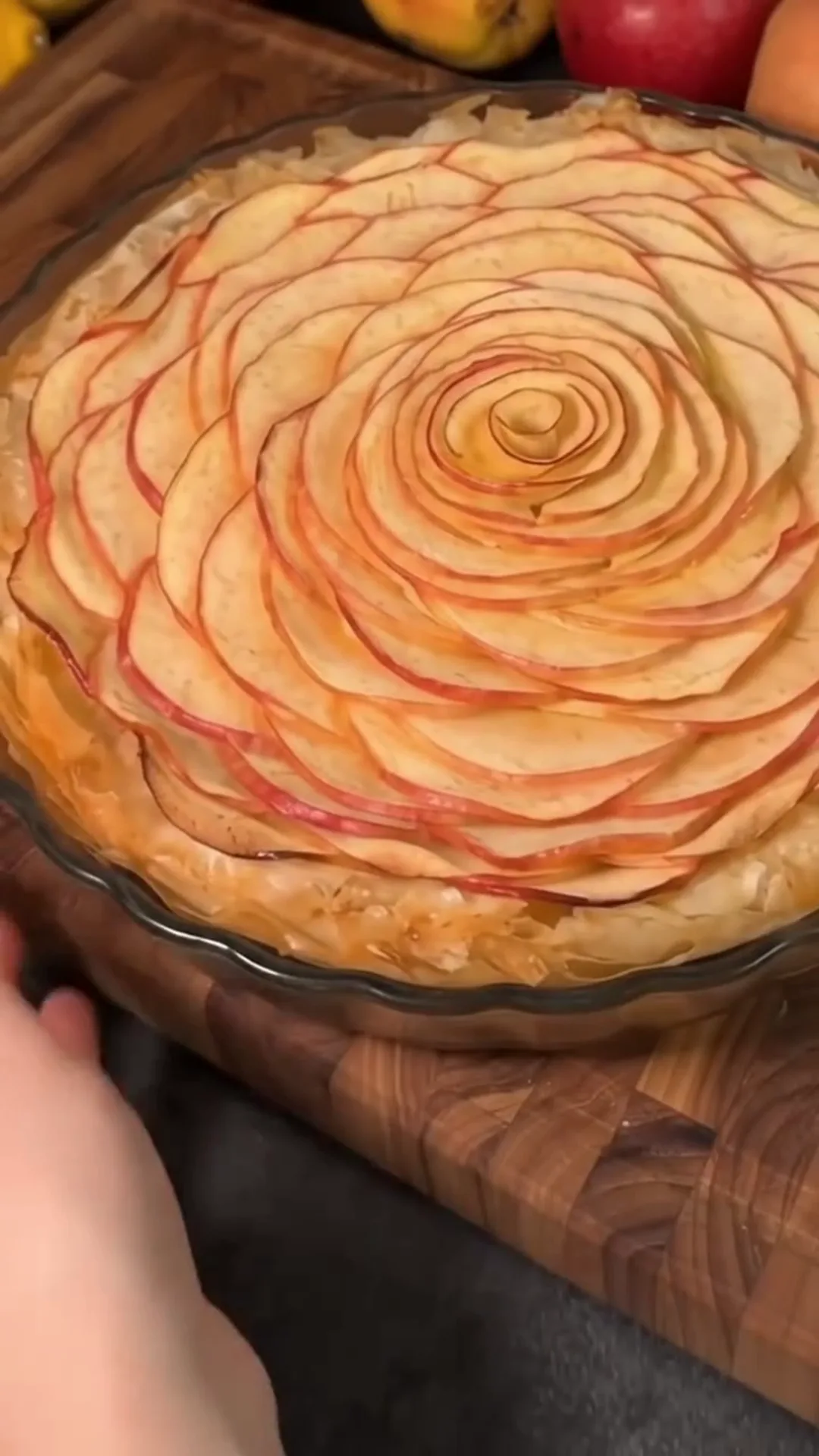 Elegant Apple Phyllo Pie with Cream Cheese Filling – A person is making an apple pie with a decorative top