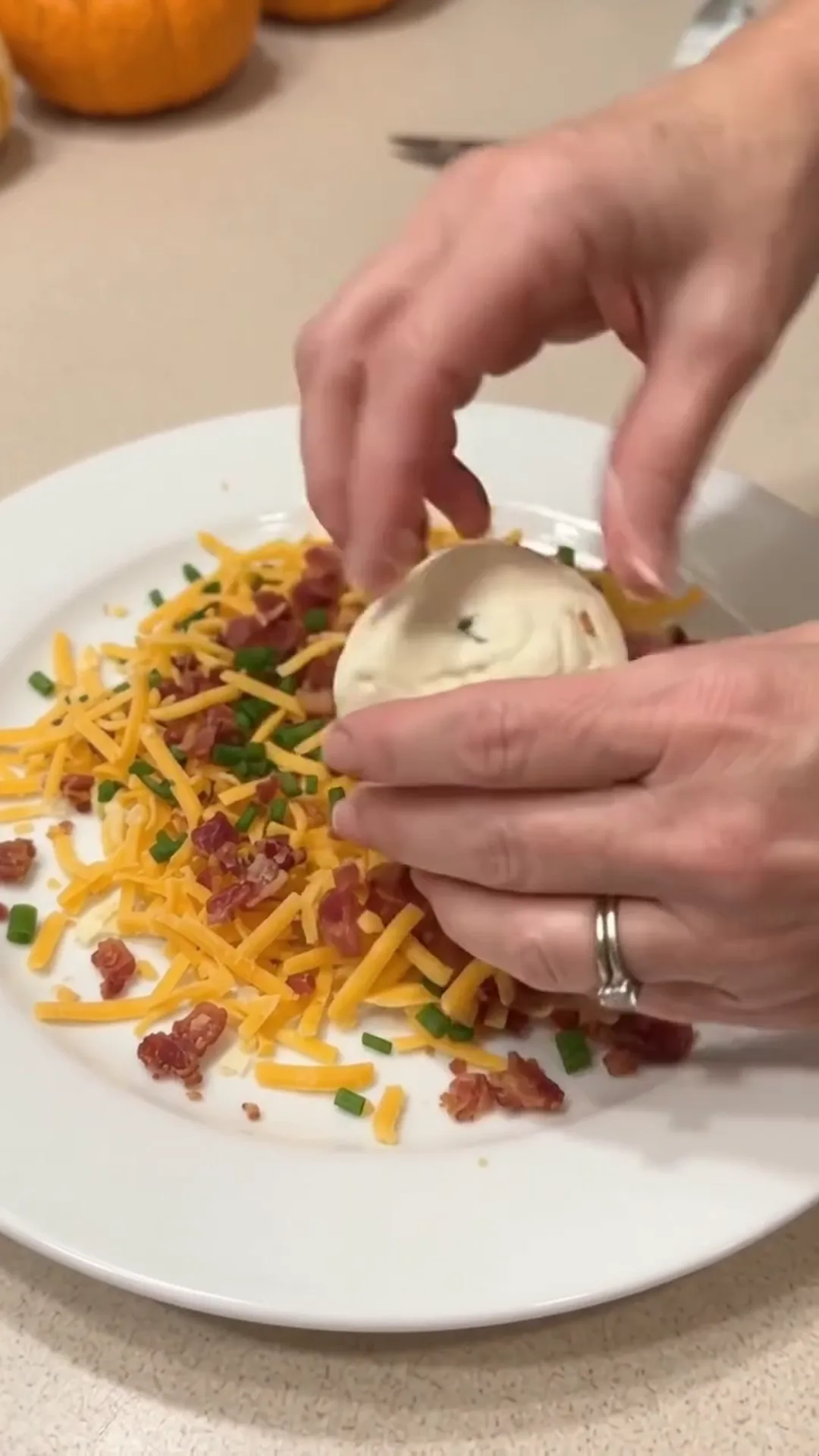 Festive Thanksgiving Turkey Cheese Ball with Crispy turkey bacon – Someone is adding cheese to a dish