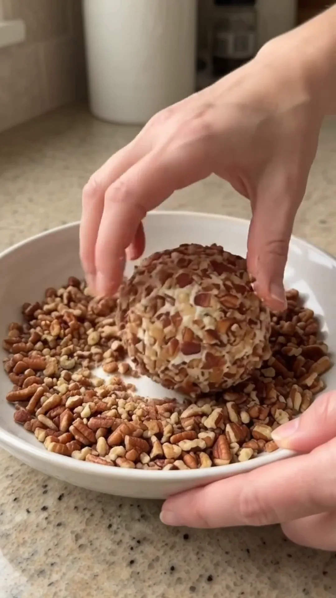 Festive Thanksgiving Turkey Cheese Ball with Crispy turkey bacon – A person is preparing a dessert with nuts