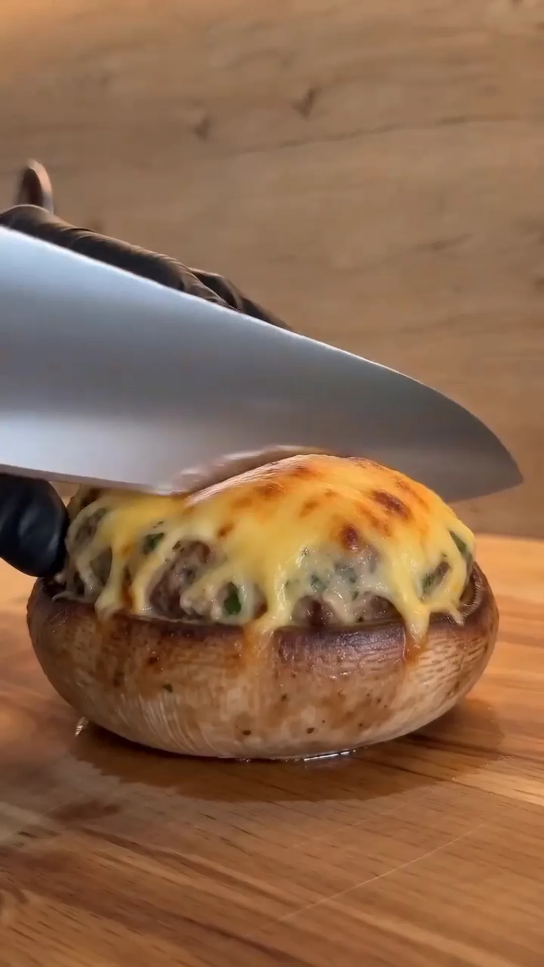Golden Cheesy Chicken Stuffed Mushrooms Recipe – A knife is cutting into a stuffed mushroom