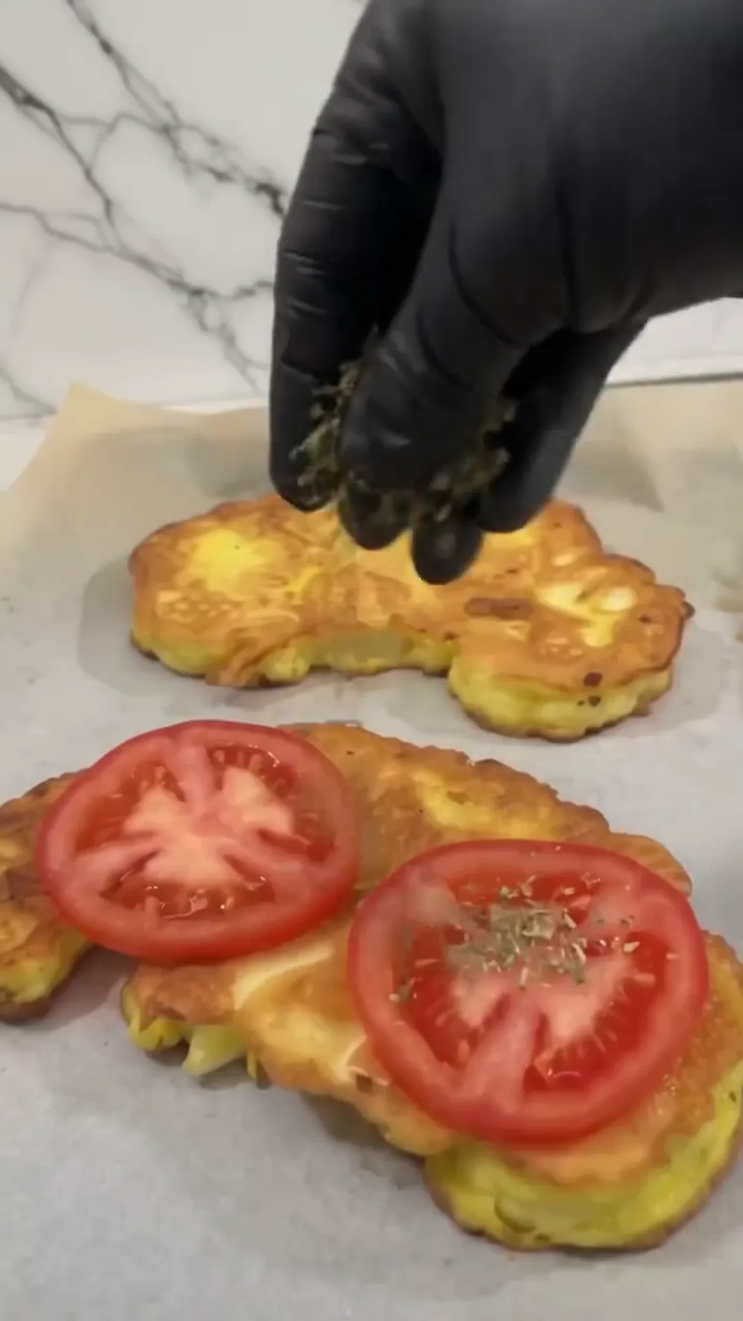 Golden Cheesy Tomato Cauliflower Steaks Recipe – Sprinkling seasoning on a tomato and cheese dish