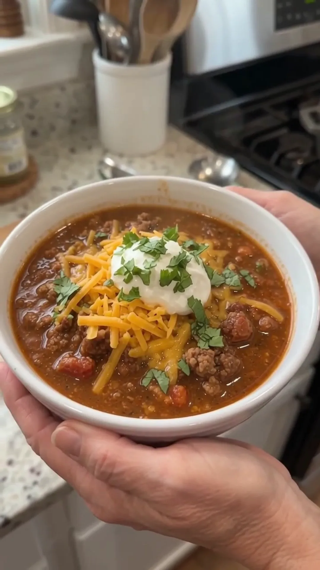 Hearty Slow Cooker Beef and Turkey Chili Recipe – A person is holding a bowl of chili