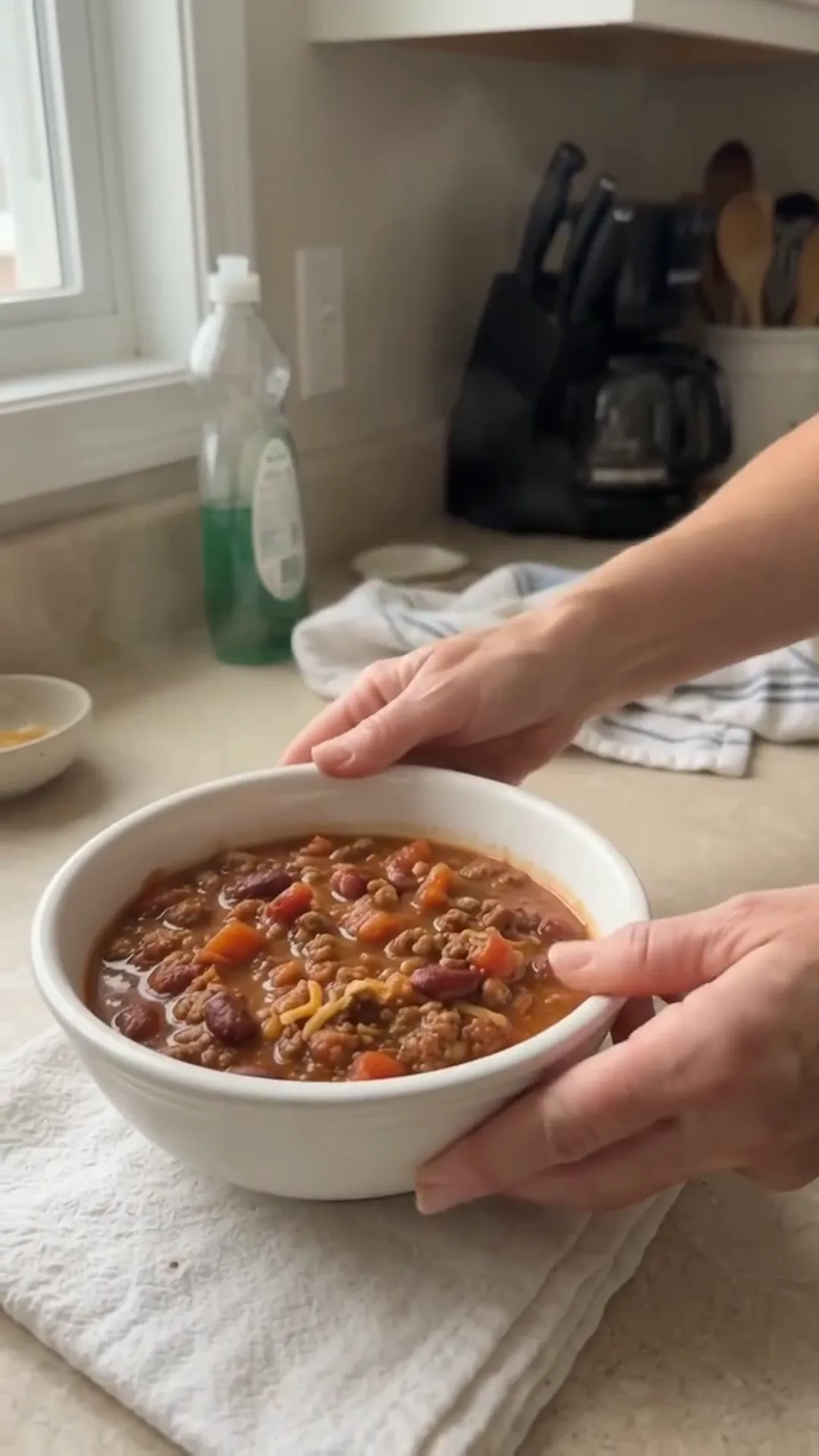 Hearty Slow Cooker Beef and Turkey Chili Recipe – A person is holding a bowl of chili