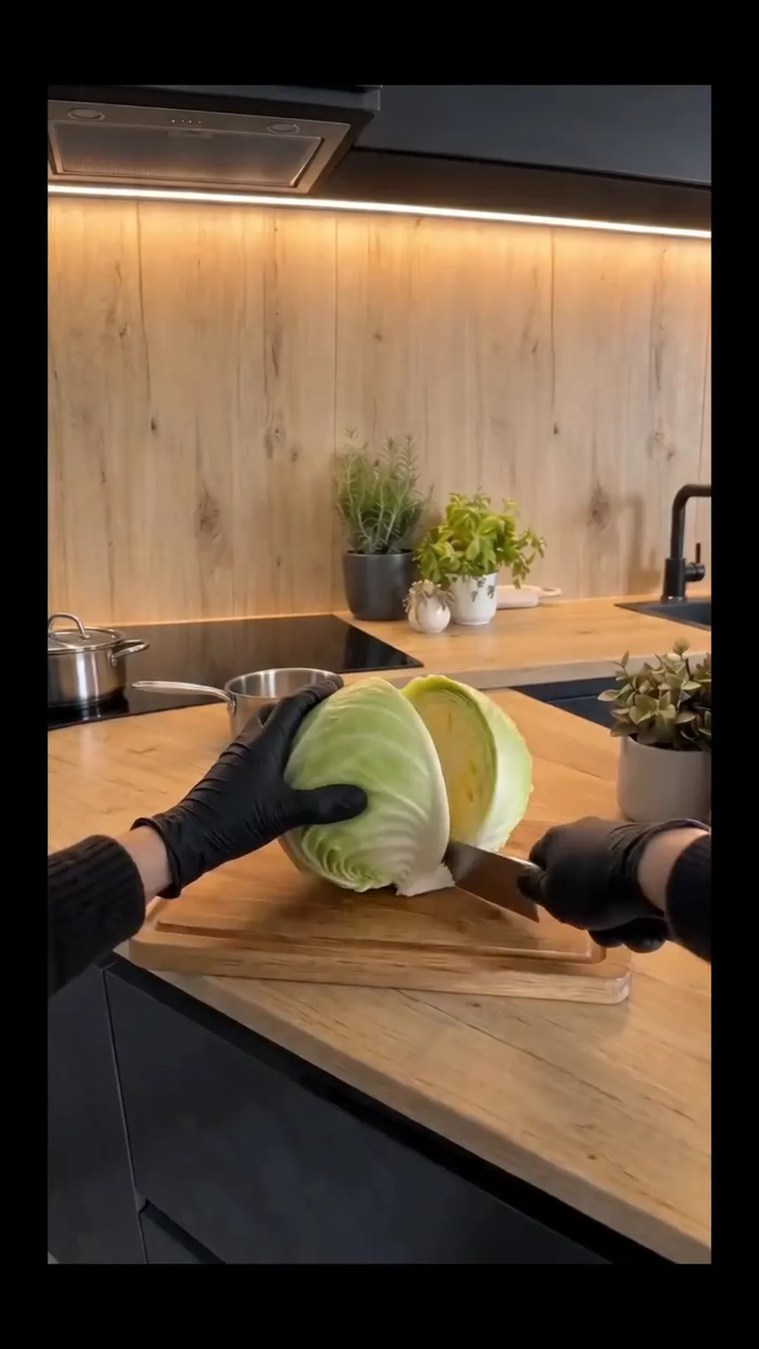 Hearty Vegan Stuffed Cabbage Rolls with Rice and Mushrooms – Someone is cutting a cabbage on a wooden cutting board