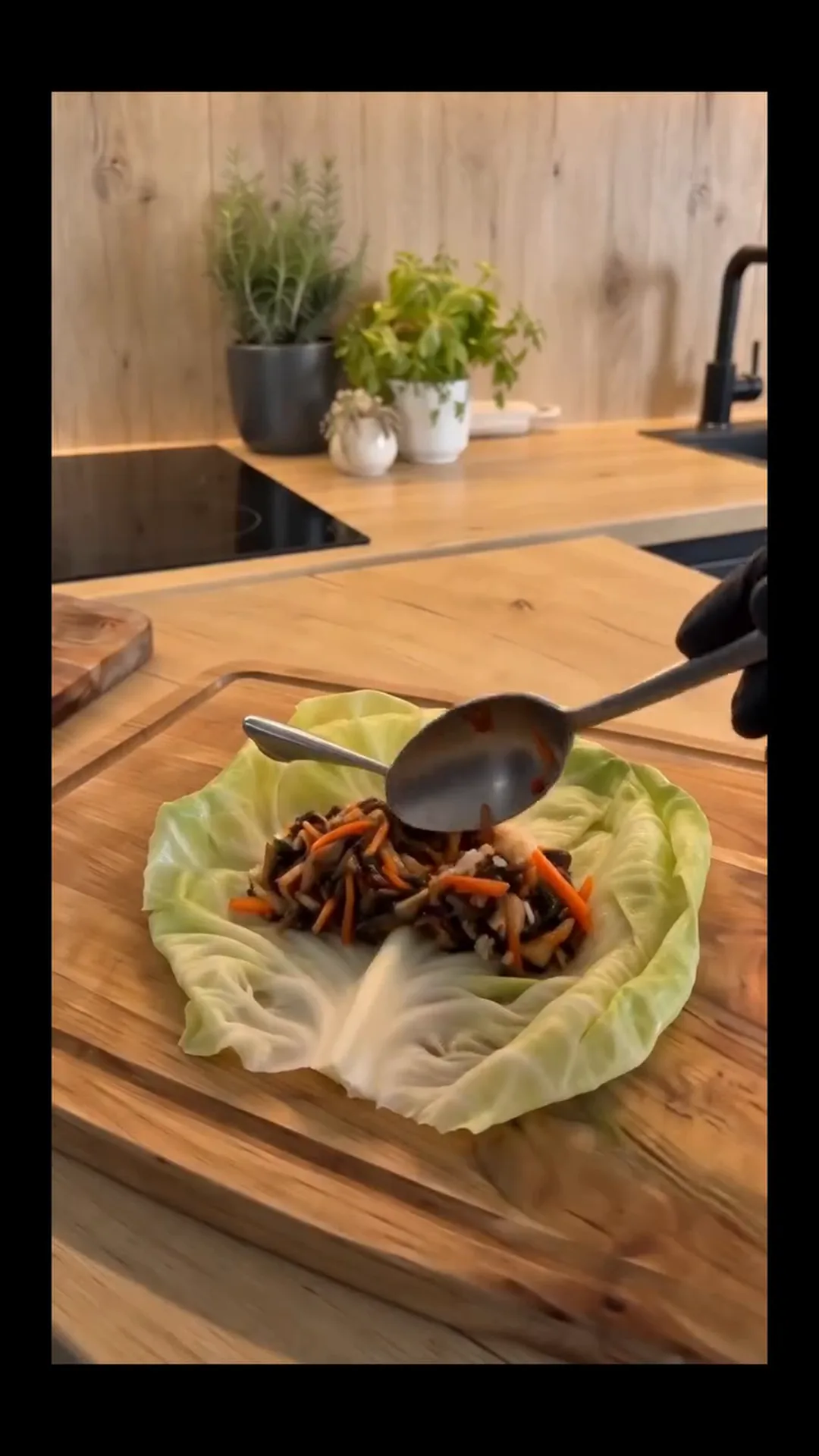 Hearty Vegan Stuffed Cabbage Rolls with Rice and Mushrooms – person is adding ingredients to a cabbage wrap