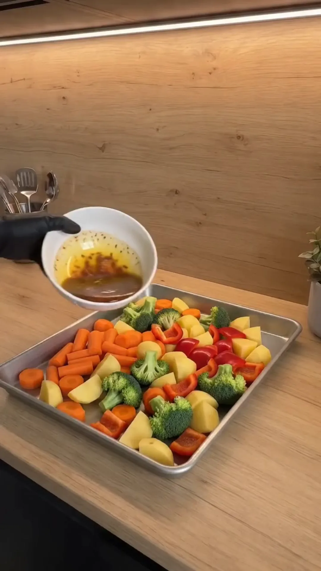 Herb-Roasted Mediterranean Vegetables with Garlic Yogurt – Pouring dressing over vegetables on a baking tray