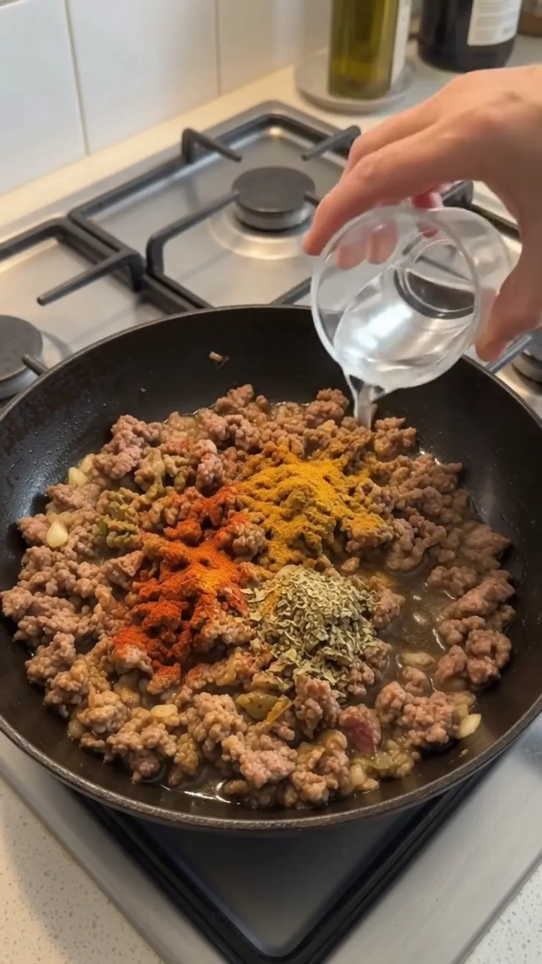 High Fiber Savory Cabbage and Ground Beef Skillet – Pouring water into a pan with ground meat and spices