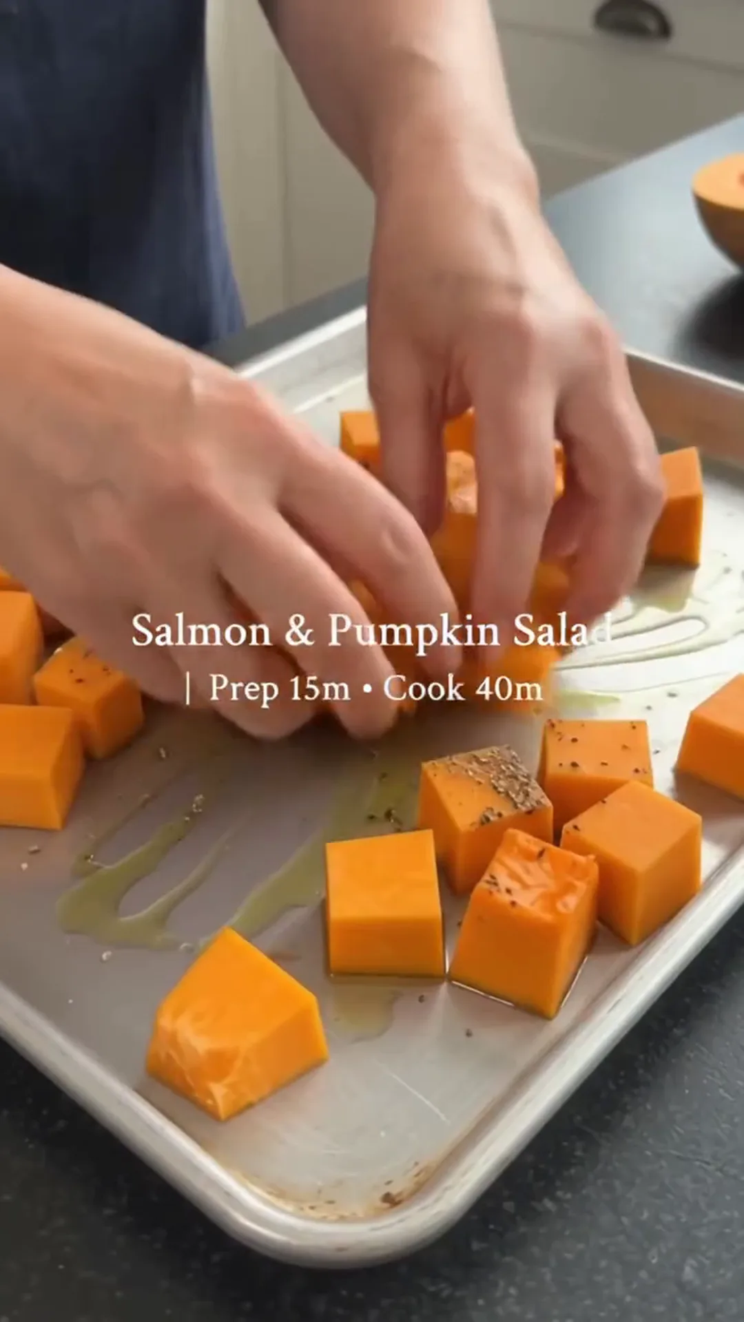 Honey-Glazed Salmon and Roasted Pumpkin Salad – person placing cubed pumpkin on a baking tray