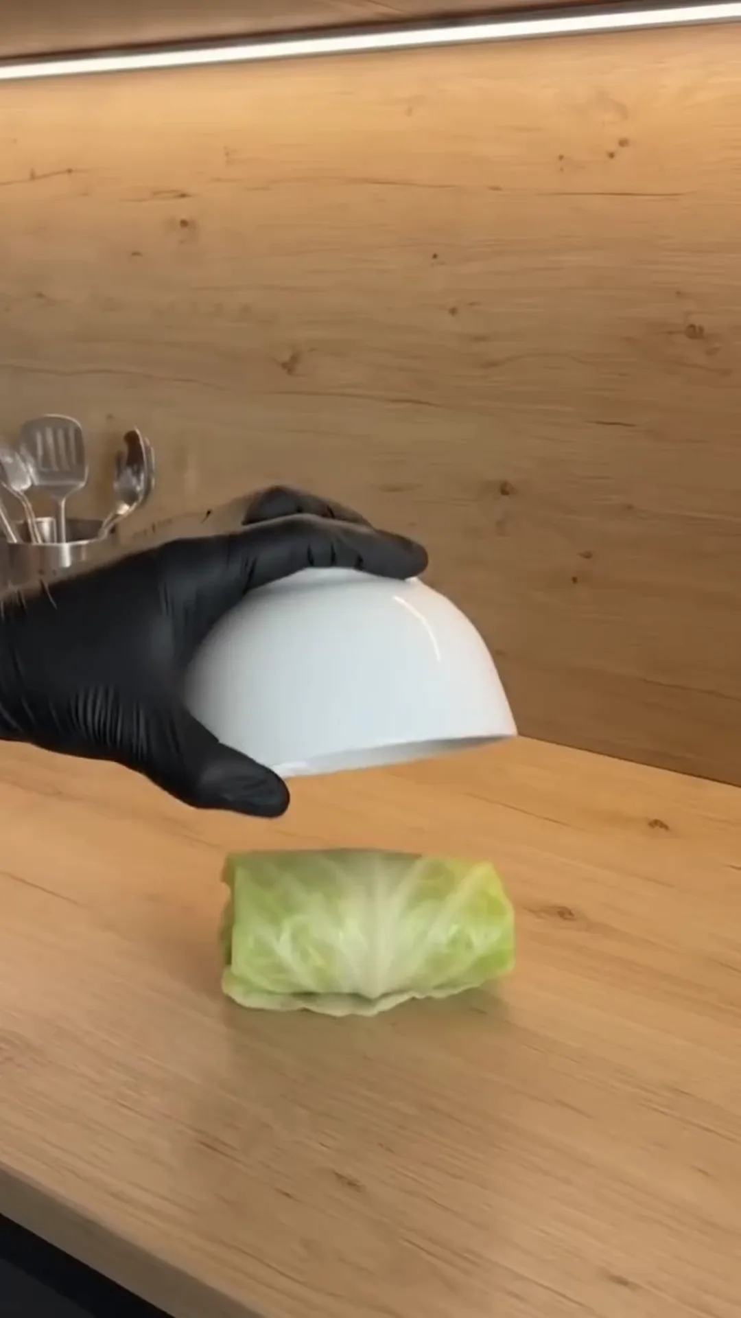 Individual Stuffed Cabbage Rolls with Ground Beef and Rice – a hand is placing a lettuce leaf on a counter