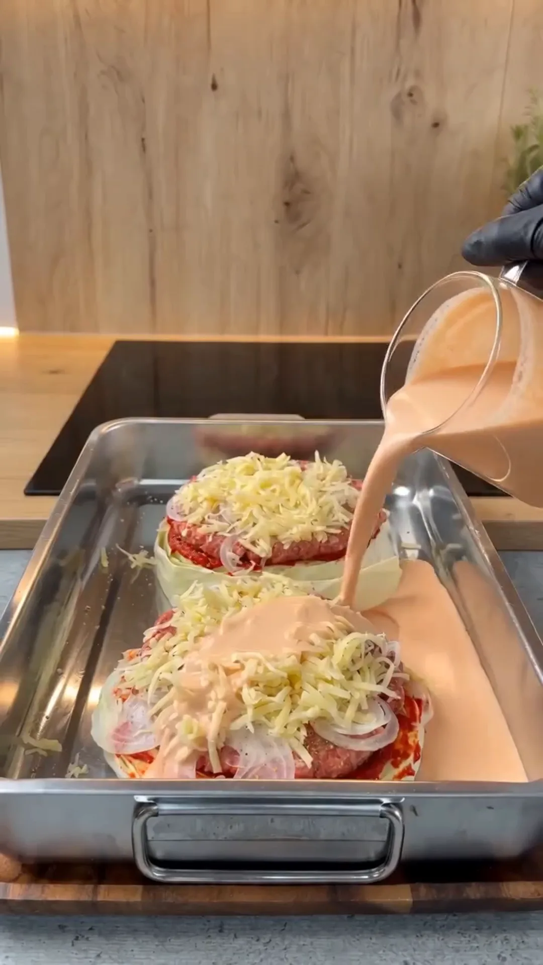 Italian Unrolled Cabbage Rolls with Creamy Tomato Sauce – Pouring sauce over food in a baking tray