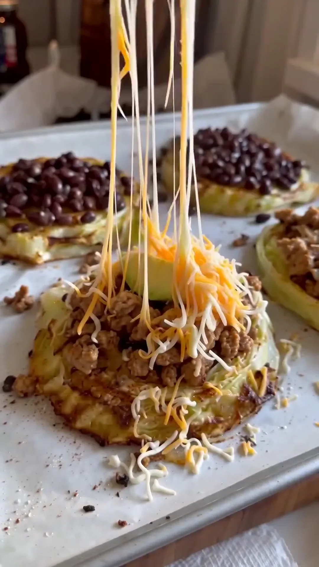 Loaded Taco Cabbage Steaks with Beef and Crema – cheese being pulled apart