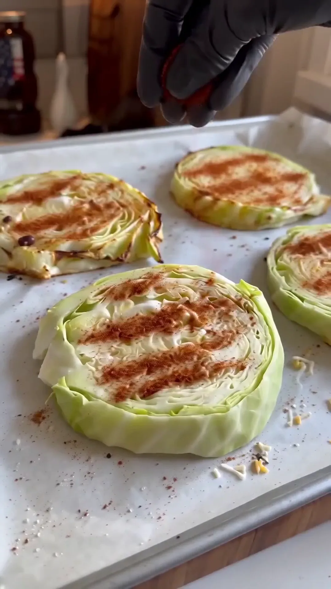 Loaded Taco Cabbage Steaks with Beef and Crema – someone is seasoning cabbage steaks