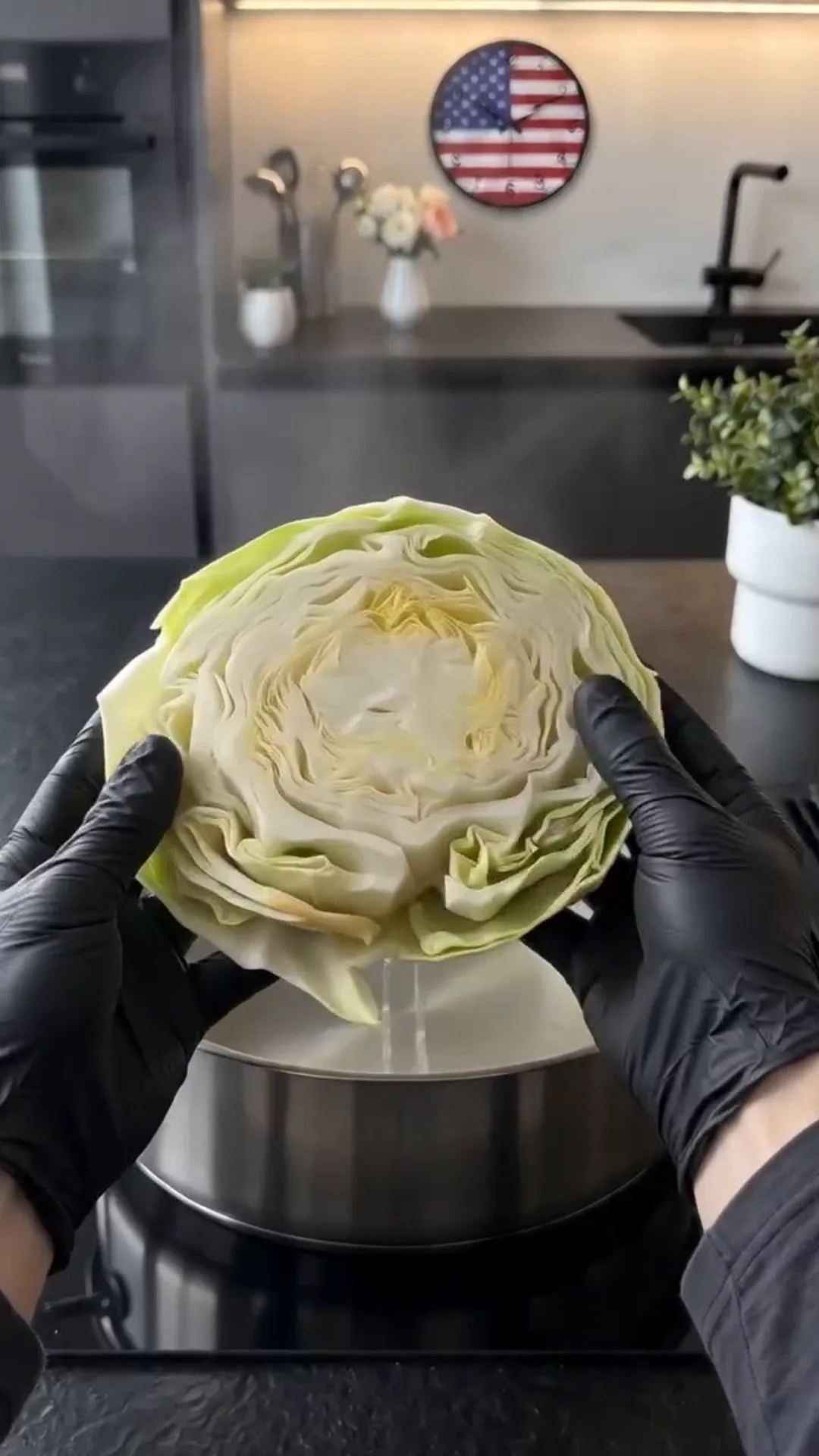 Miso Glazed Cabbage Flowers with Tahini and Cashews – A person is holding a head of cabbage over a pot