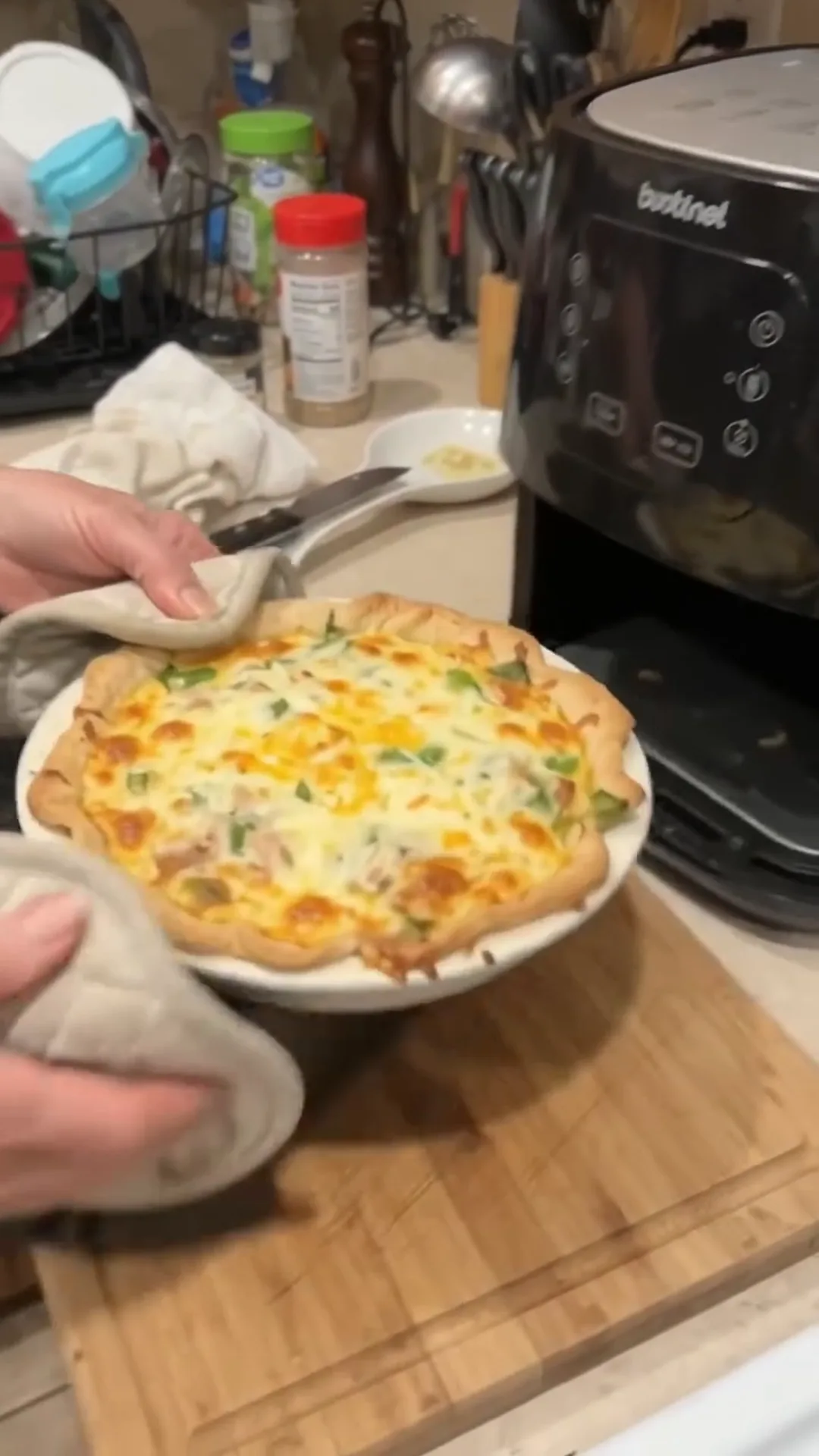 Quick Cauliflower Pizza Steaks with Smoked Turkey and Cheese – Someone is serving a cheesy dish from a pie plate