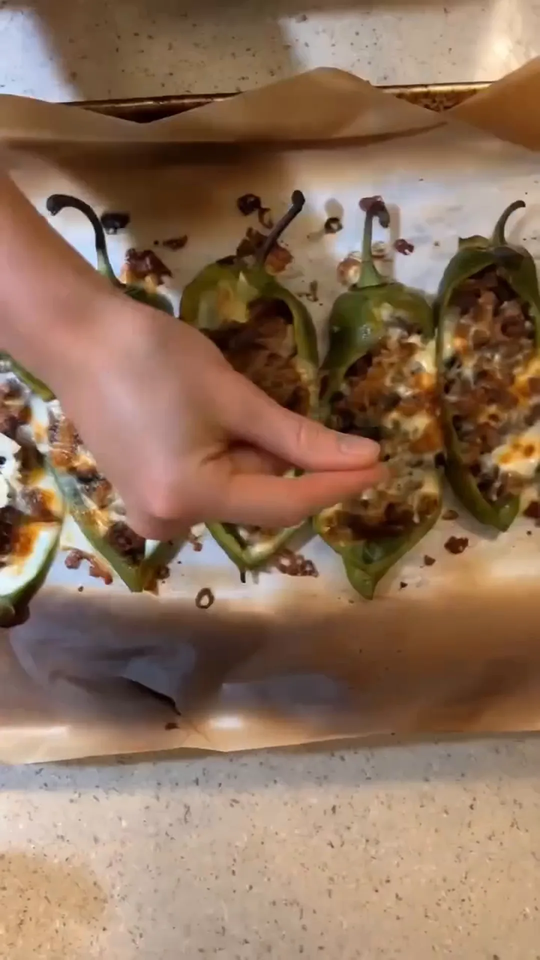 Roasted Anaheim Chile Tacos with Seasoned Beef and Cheese – hand placing stuffed peppers on a baking tray