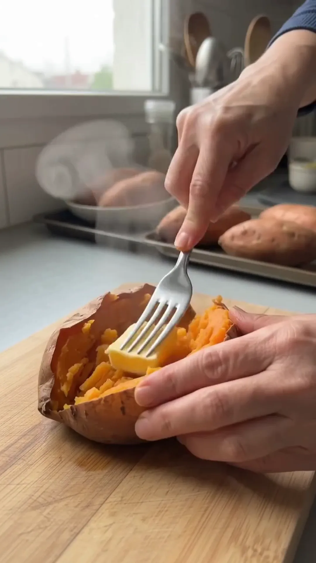 Roasted Stuffed Sweet Potatoes with Seasoned Beef and Corn – person adding butter to a baked sweet potato