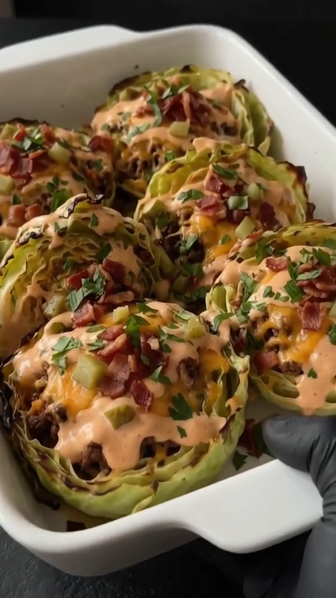 Savory Cheeseburger Cabbage Cups with Melted Cheese – someone is holding a tray of baked cabbage