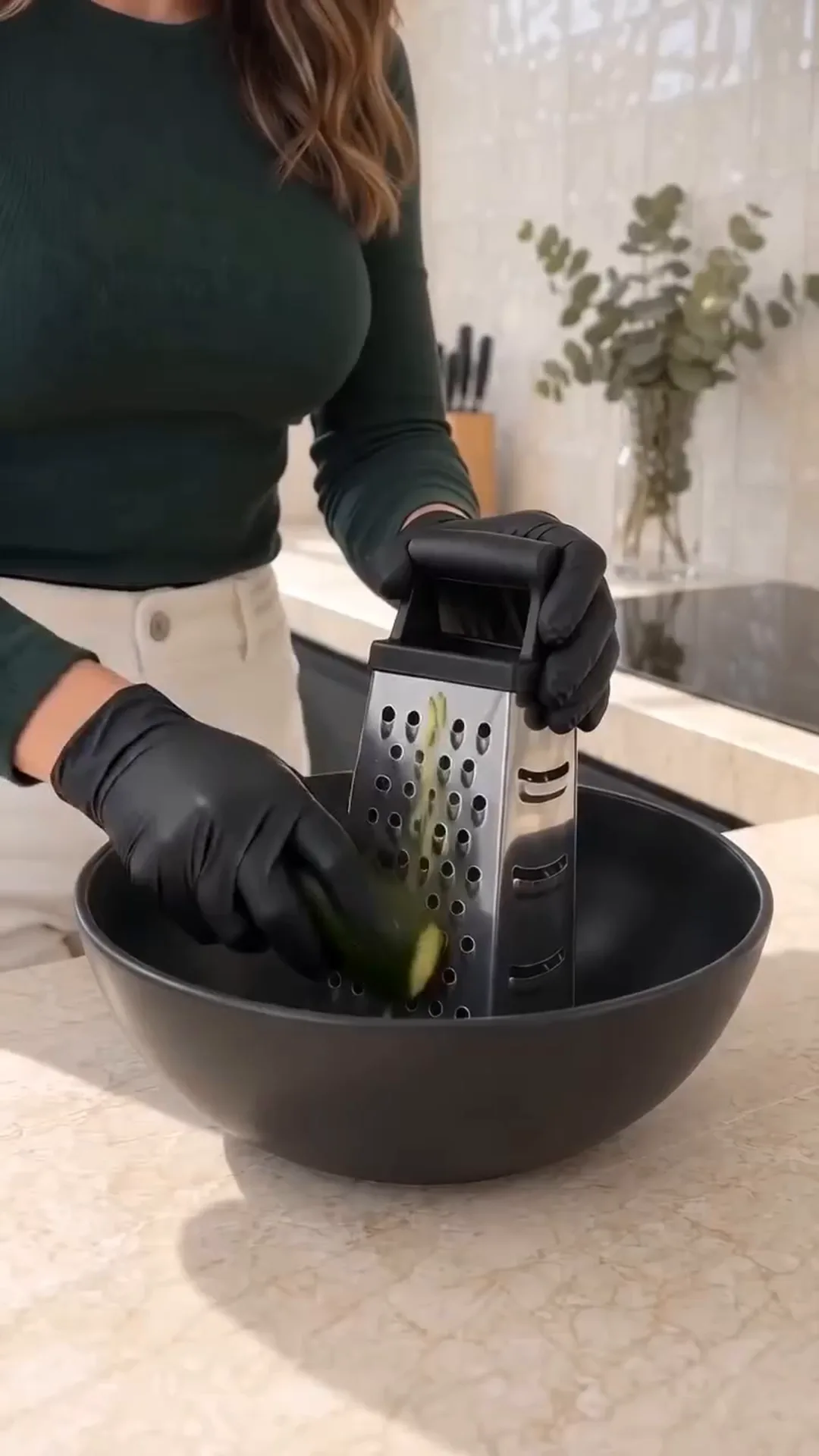 Savory Cheesy Baked Zucchini Loaf with Melted Center – A woman is grating a vegetable into a bowl
