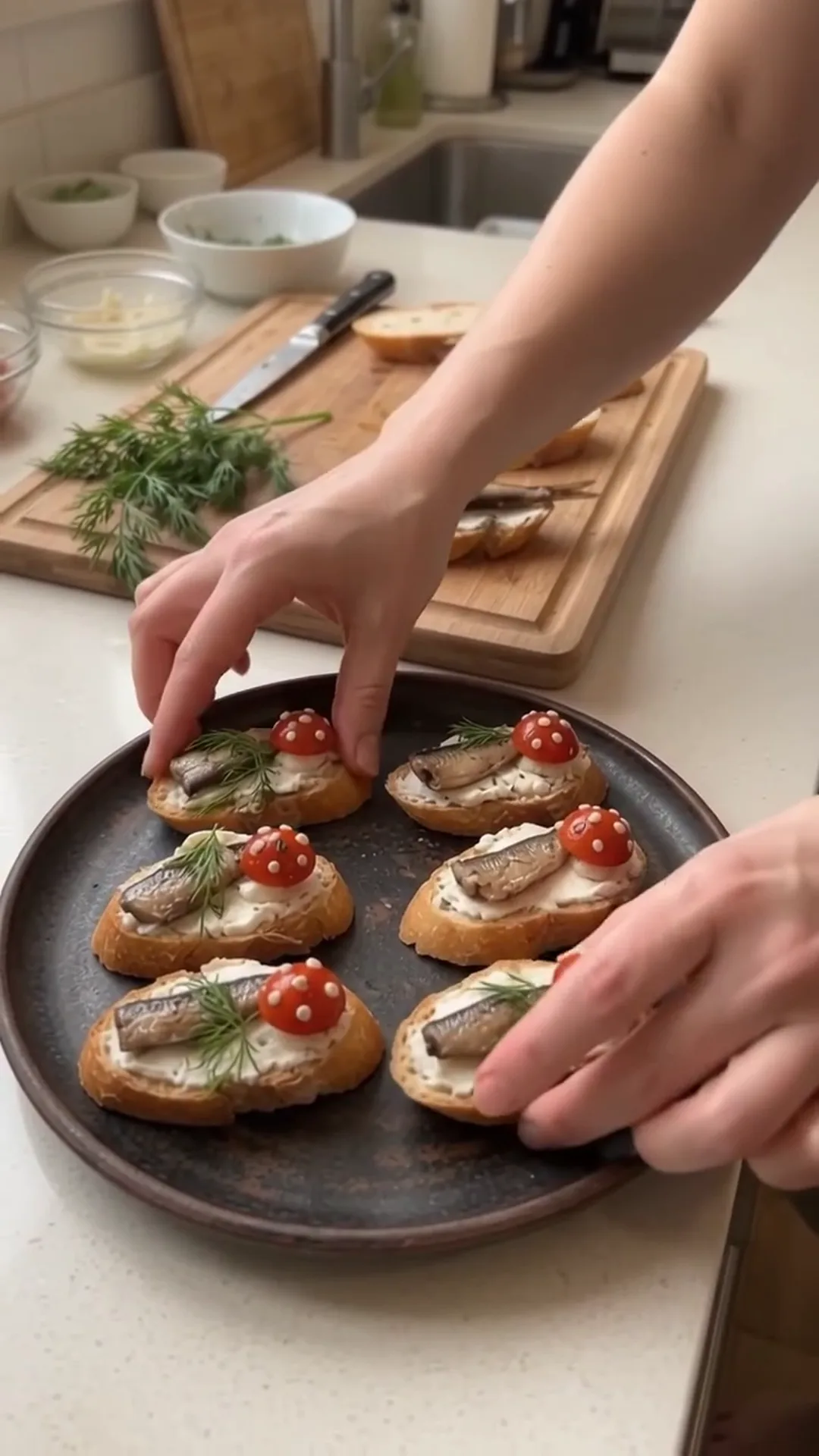 Smoked Sprat and Cream Cheese Baguette Bites – A person is preparing small open-faced sandwiches on a plate