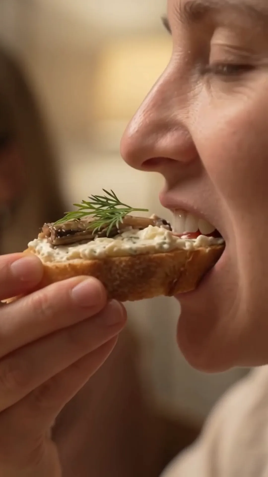 Smoked Sprat and Cream Cheese Baguette Bites – woman eating a small sandwich with cream cheese and dill