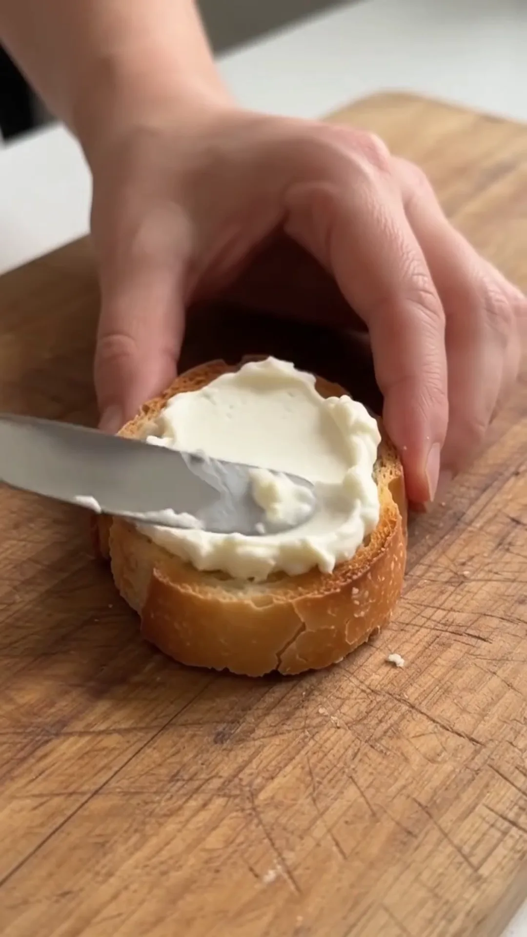 Smoked Sprat and Cream Cheese Baguette Bites – spreading cream cheese on bread