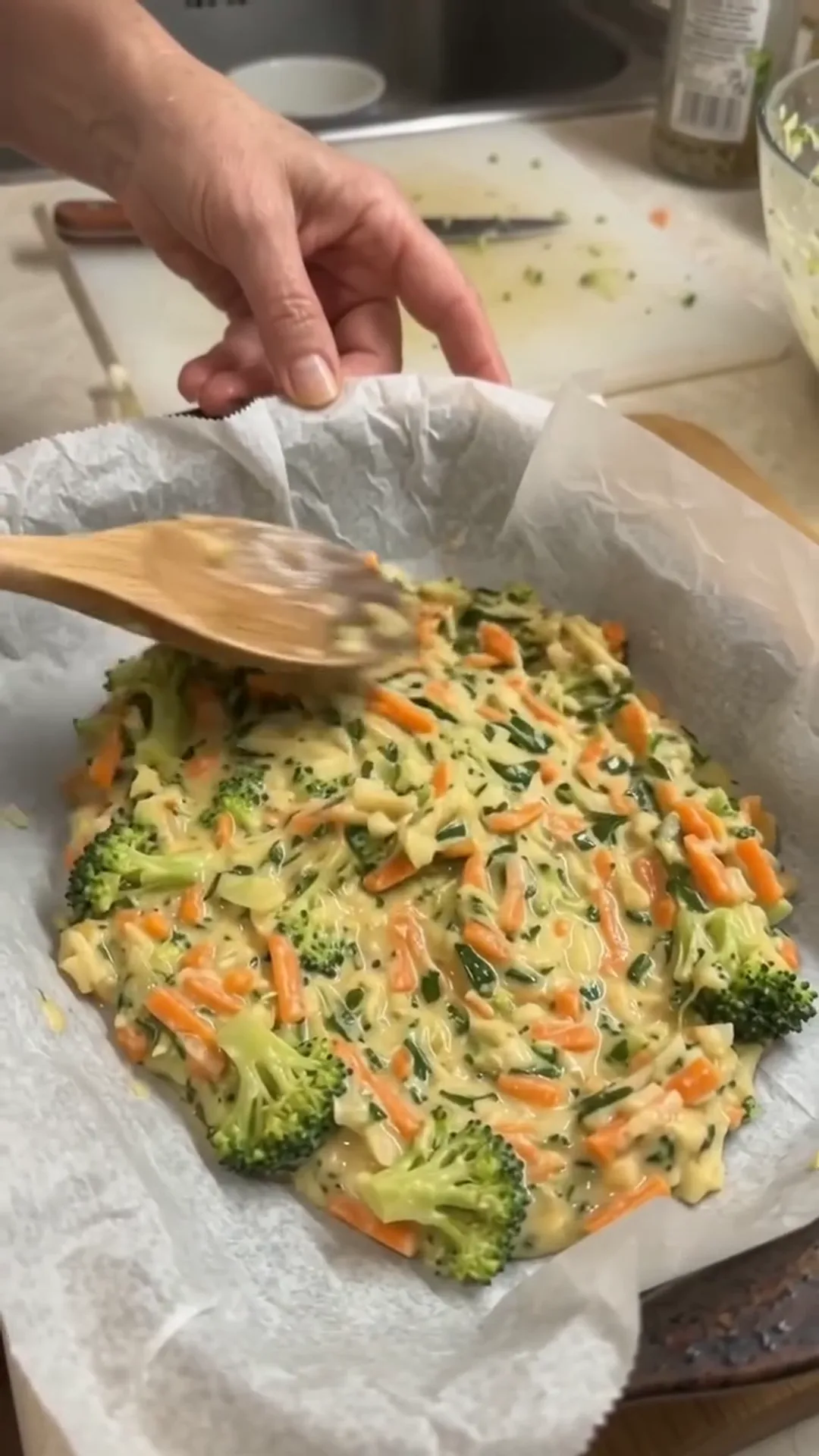 Smoked Turkey and Broccoli Egg Frittata Bake – person stirring a mixture of vegetables in a bowl
